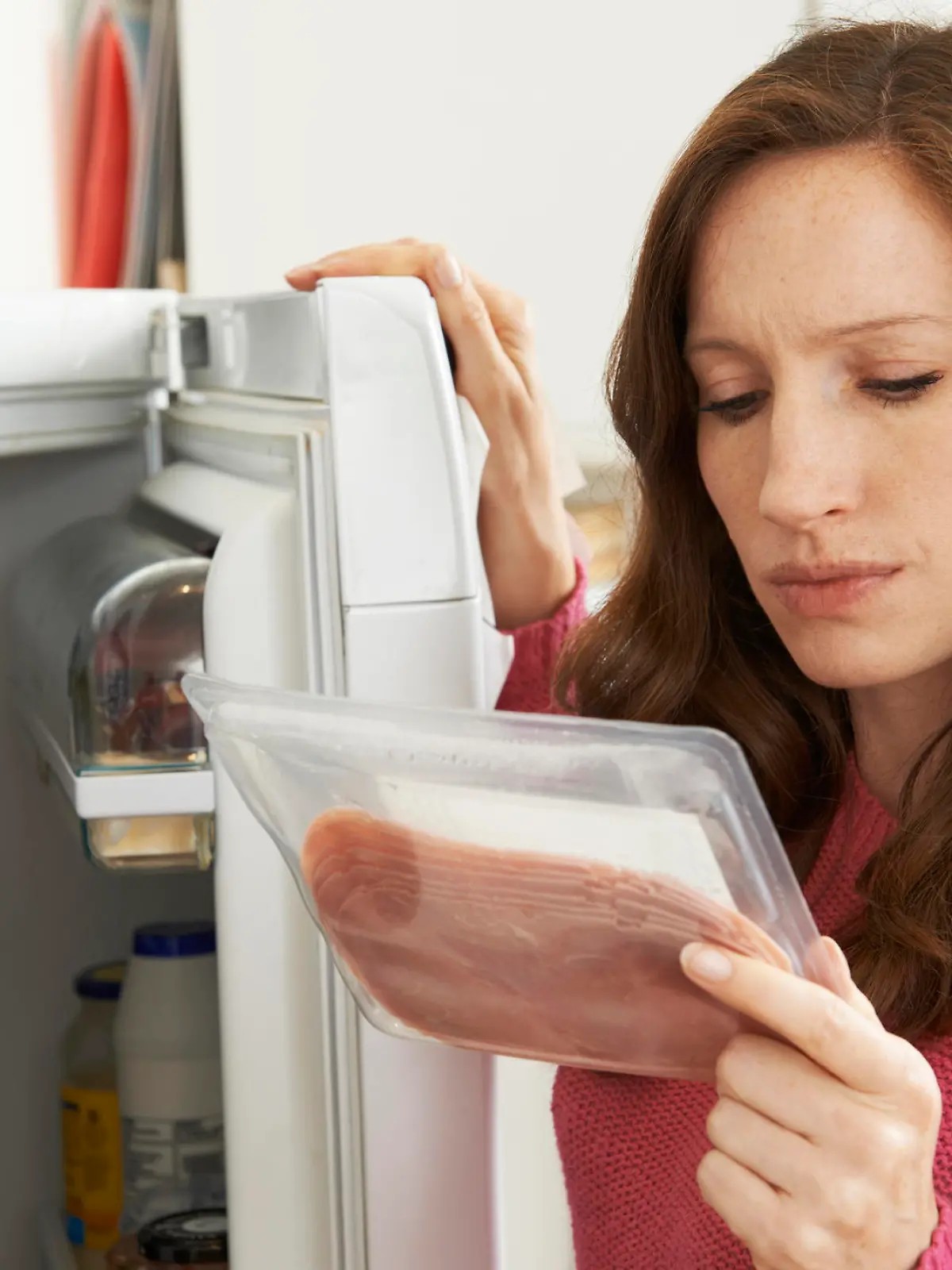 Concerned Woman Looking At Pre Packaged Meat