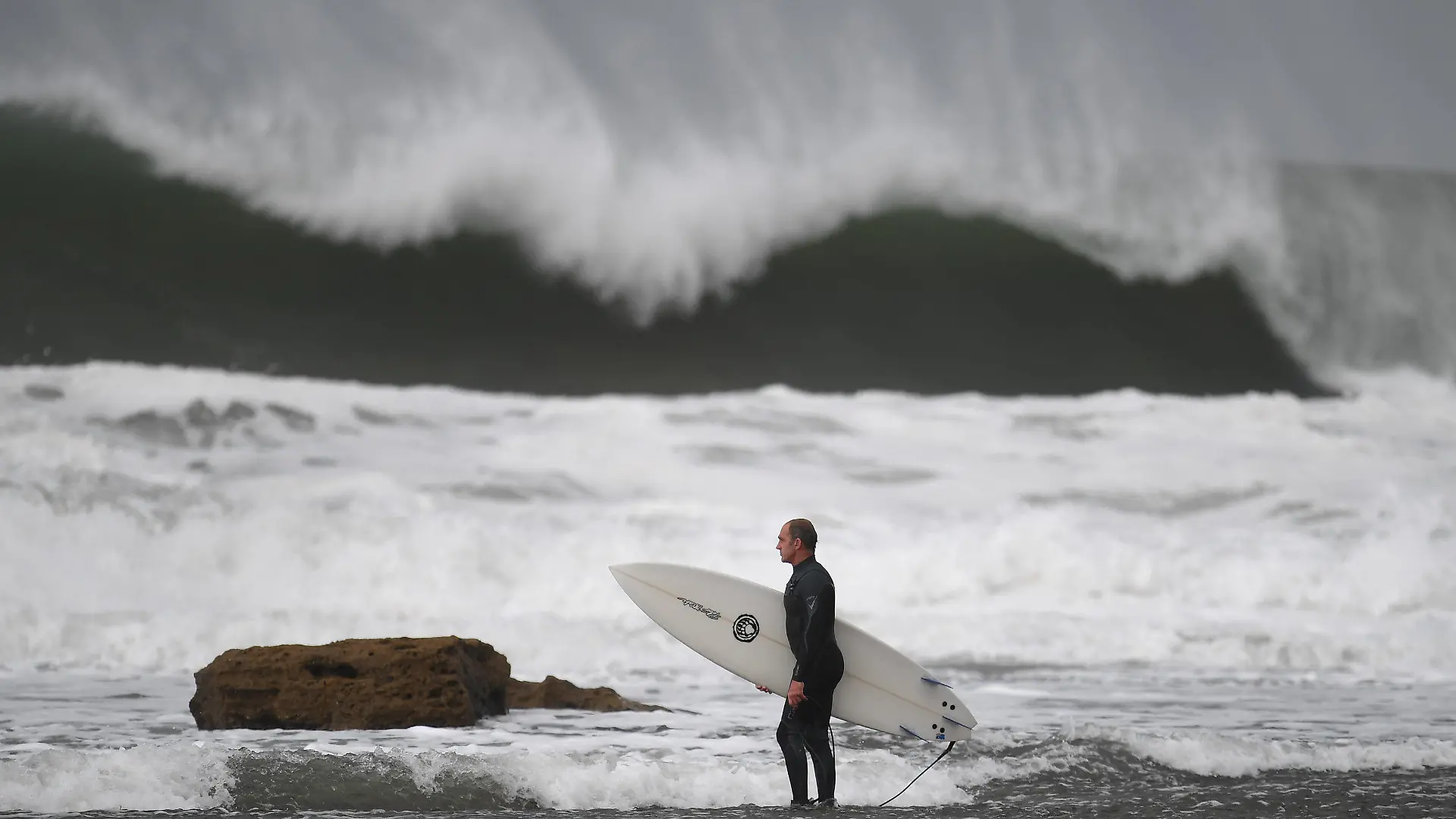 29.05.2019, Australien, Melbourne: Ein Surfer macht sich bereit, um am Winkipop in der Nähe von Bells Beach im südöstlichen Bundesstaat Victoria zu surfen. Eine Kaltfront sorgt für große Wellen, Wind und Regen. Foto: Julian Smith/AAP/dpa +++ dpa-Bildfunk +++