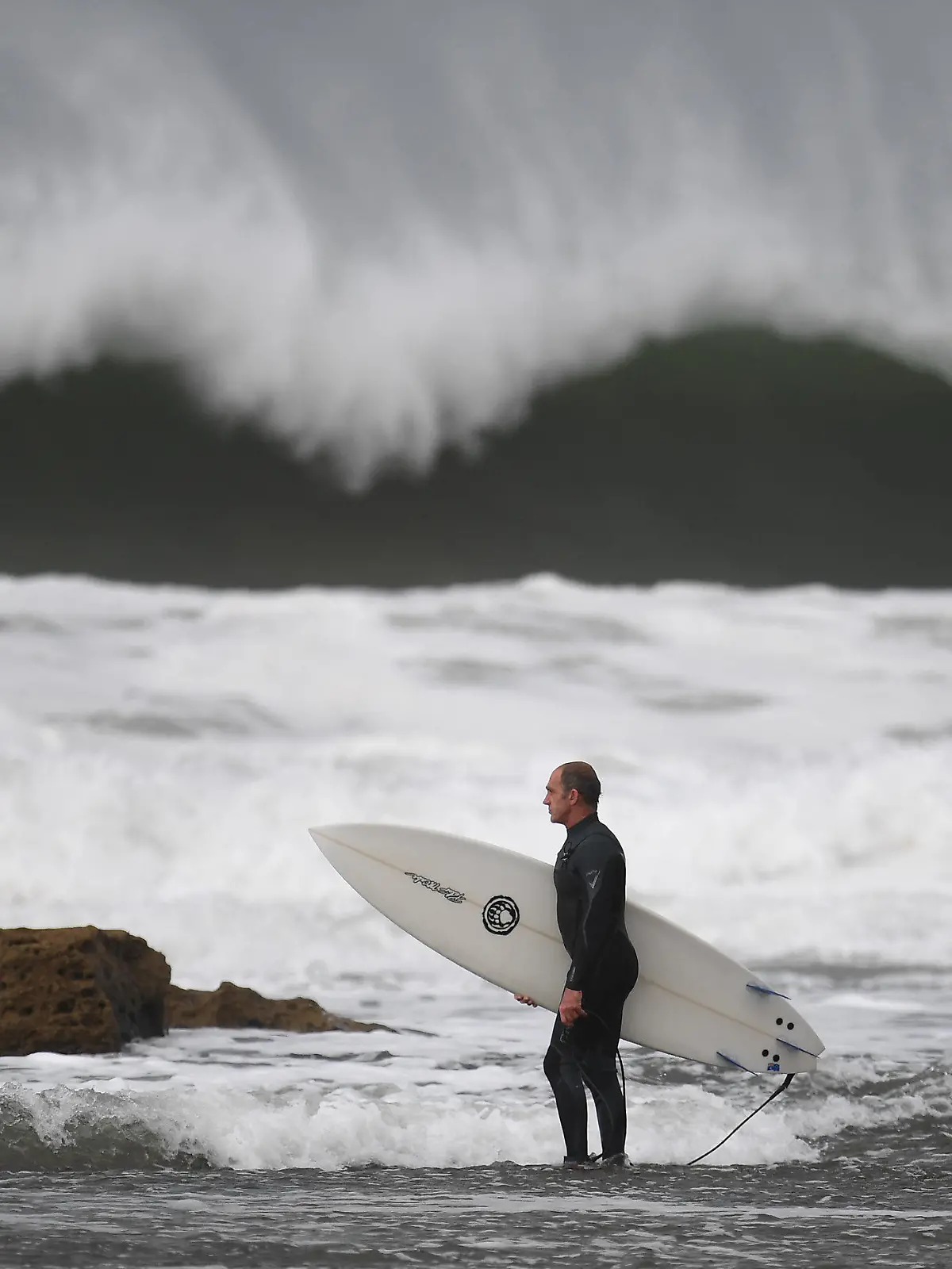 29.05.2019, Australien, Melbourne: Ein Surfer macht sich bereit, um am Winkipop in der Nähe von Bells Beach im südöstlichen Bundesstaat Victoria zu surfen. Eine Kaltfront sorgt für große Wellen, Wind und Regen. Foto: Julian Smith/AAP/dpa +++ dpa-Bildfunk +++