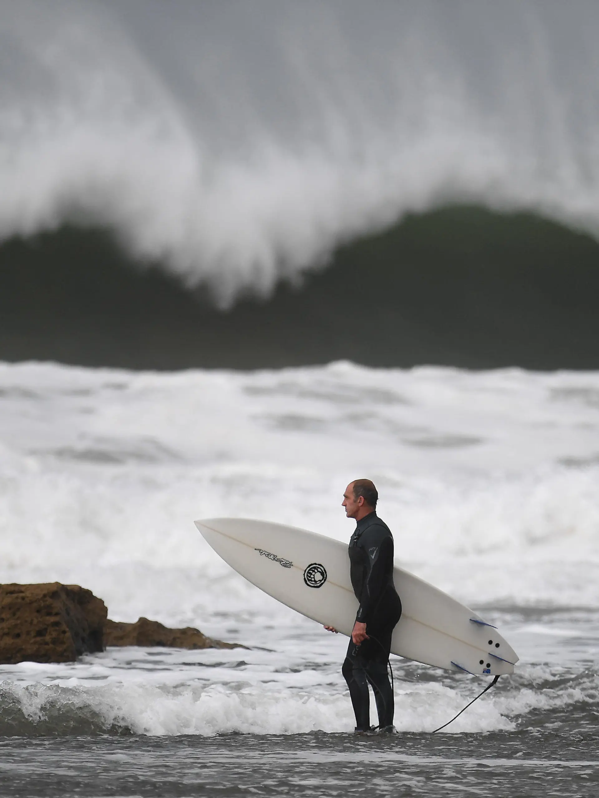 29.05.2019, Australien, Melbourne: Ein Surfer macht sich bereit, um am Winkipop in der Nähe von Bells Beach im südöstlichen Bundesstaat Victoria zu surfen. Eine Kaltfront sorgt für große Wellen, Wind und Regen. Foto: Julian Smith/AAP/dpa +++ dpa-Bildfunk +++