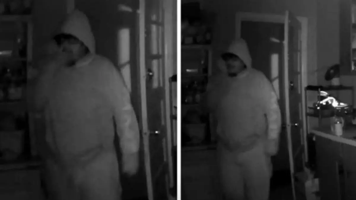 Ein Mann in einem dunklen Raum gefilmt von einer Überwachungskamera.