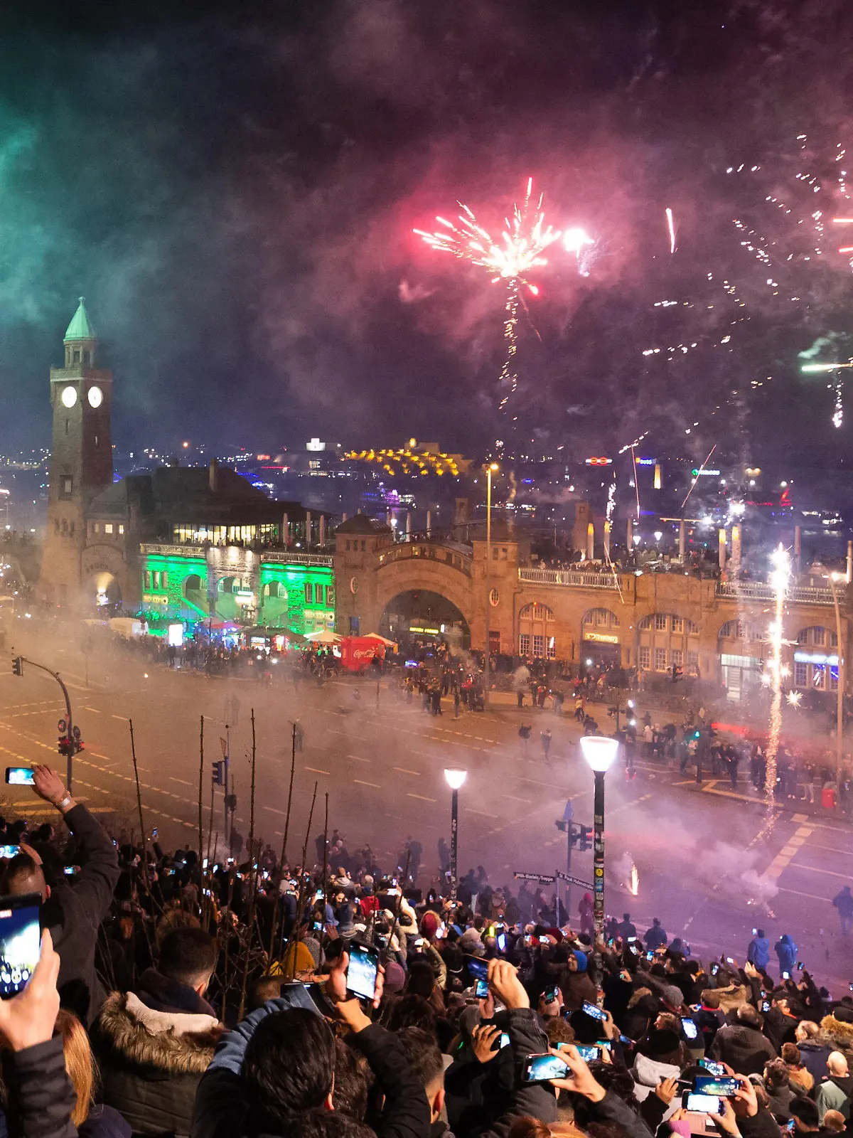ARCHIV - 01.01.2020, Hamburg: Schaulustige beobachten um Mitternacht das Feuerwerk an den Hamburger Landungsbrücken. Rund um die Binnenalster und auf dem Rathausmarkt bleibt das Böllern in diesem Jahr verboten. (zu dpa: Feuerwerk rund um Binnenalster und auf Rathausmarkt verboten) Foto: Jonas Walzberg/dpa +++ dpa-Bildfunk +++
