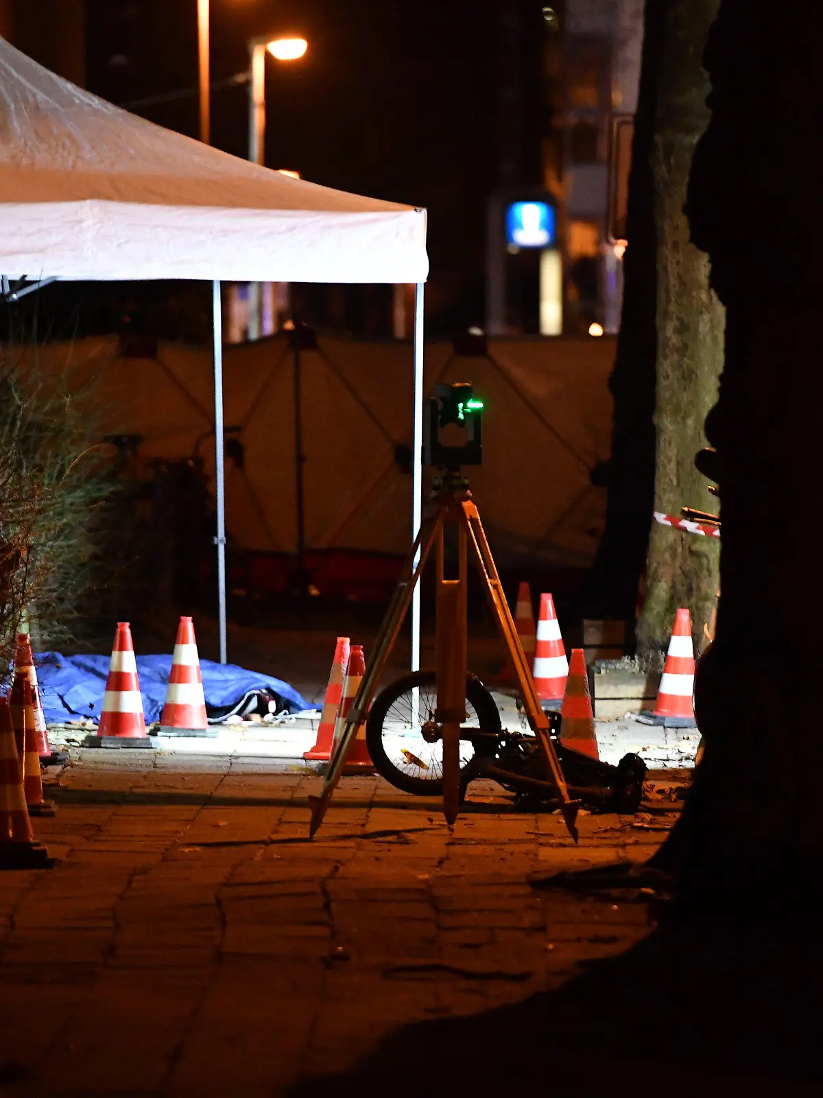 28.12.2023, Berlin: Pylonen und ein Zeltdach stehen an einem Tatort im Berliner Stadtteil Pankow, eine blaue Plane bedeckt einen Toten. Passanten hatten vor einem Hauseingang im Berliner Stadtteil Pankow den blutüberströmten und leblosen Körper eines Mannes gefunden, der mutmaßlich Opfer eines Verbrechens geworden war. Foto: Paul Zinken/dpa +++ dpa-Bildfunk +++