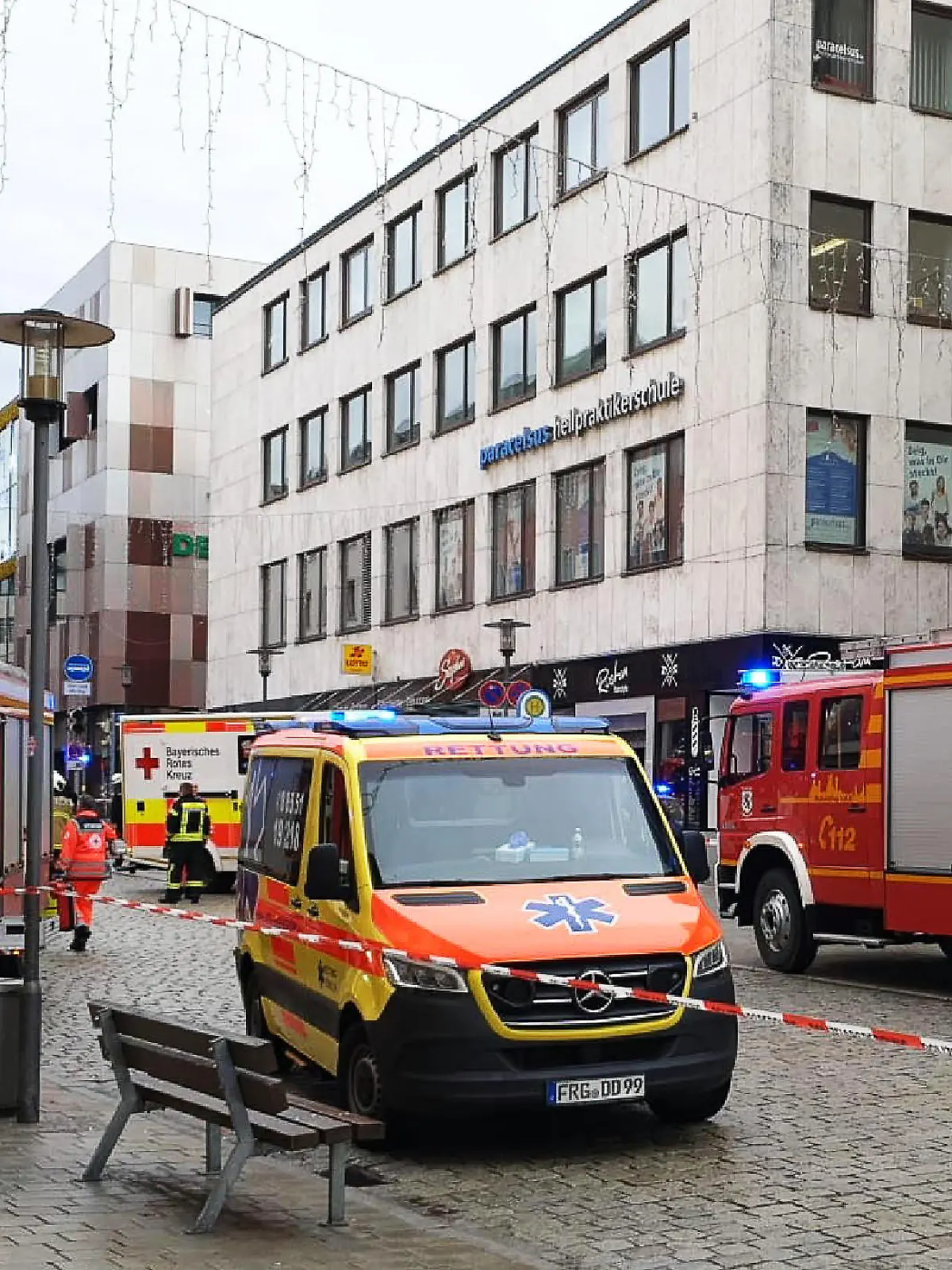 29.12.2023, Bayern, Passau: Einsatzkräfte von Feuerwehr und Rettungsdienst stehen in der Innenstadt am Einsatzort. Ein Lastwagen ist in der Passauer Innenstadt in eine Fußgängergruppe gefahren und hat dabei mehrere Menschen verletzt und eine Frau getötet. Auch der Lastwagenfahrer sei auf dem Weg ins Krankenhaus, sagte ein Polizeisprecher. Foto: -/Zema Medien/dpa +++ dpa-Bildfunk +++
