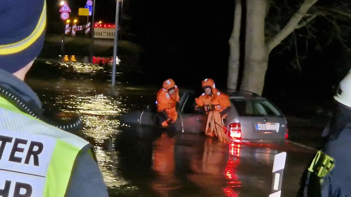 Einsatzkräfte der Feuerwehr Meinersen bergen ein abgetriebenes Auto aus dem Hochwasser.