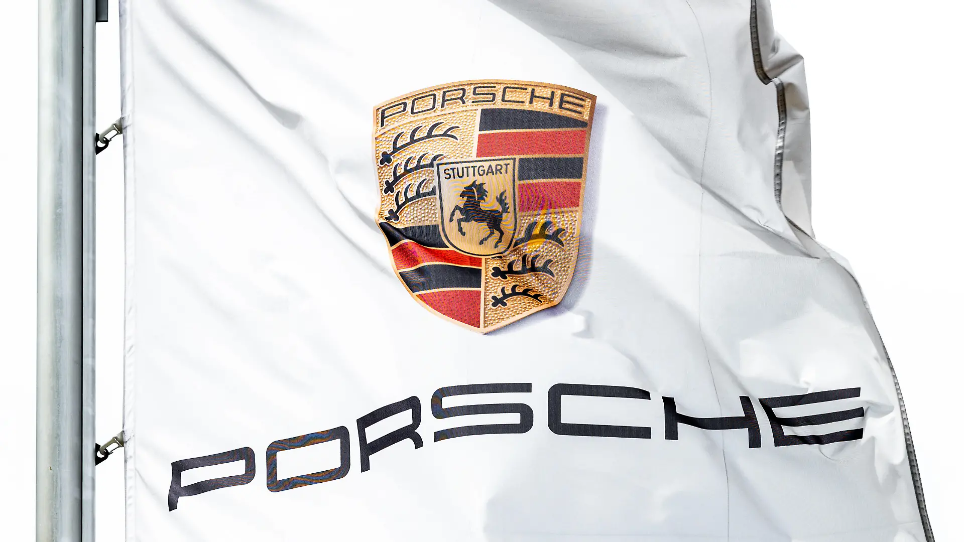 Das Logo von Porsche ist auf einer Flagge vor dem Porsche Zentrum Schwarzwald-Baar zu sehen, die im Wind weht. Villingen-Schwenningen Baden-Württemberg Deutschland *** The Porsche logo can be seen on a flag in front of the Porsche Centre Schwarzwald Baar blowing in the wind Villingen Schwenningen Baden Württemberg Germany