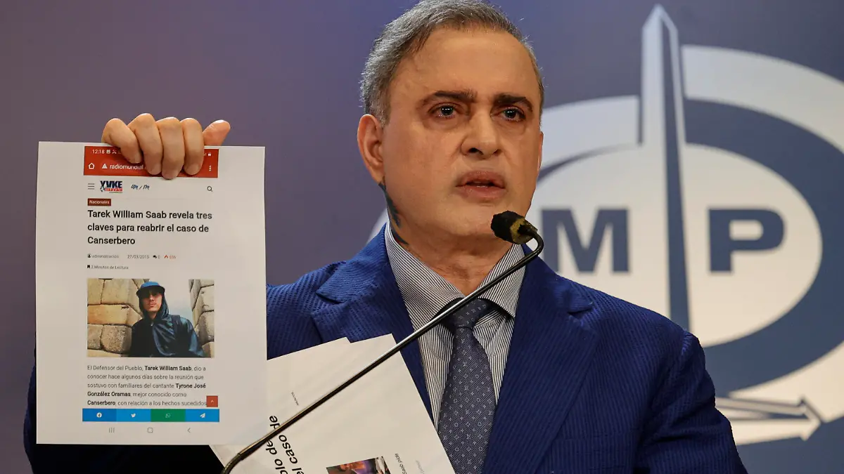 26.12.2023, Venezuela, Caracas: Tarek William Saab, Venezuelas Generalstaatsanwalt, zeigt auf einer Pressekonferenz einen gedruckten Zeitungsartikel mit einem Bild des Rappers Canserbero. Der Rapper soll von seiner damaligen Managerin Natalia Amestica umgebracht worden sein. (zu dpa «Wende im Todesfall von Venezuelas Rapper Canserbero - nach Jahren») Foto: Jesus Vargas/dpa +++ dpa-Bildfunk +++