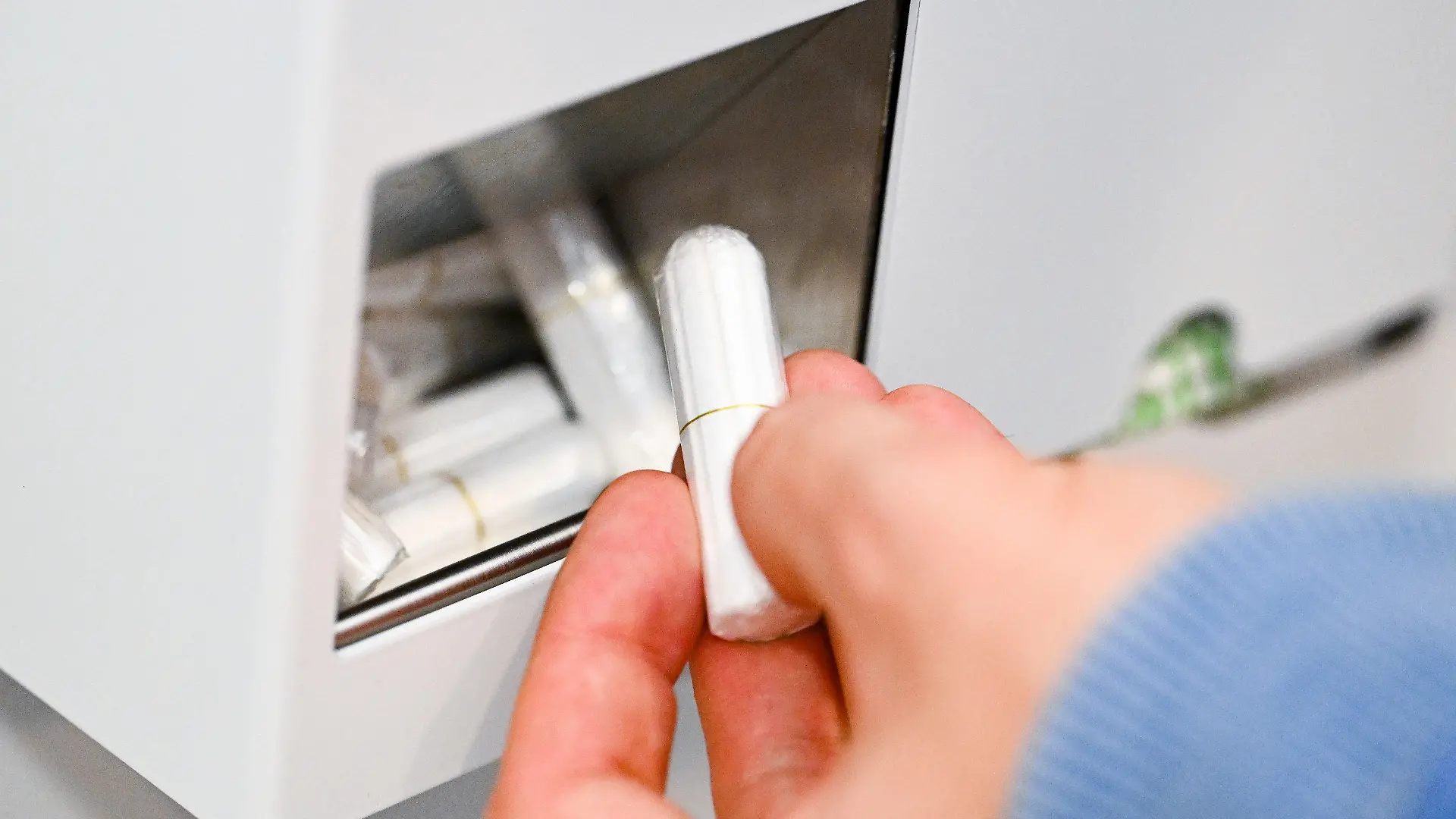 20.10.2022, Baden-Württemberg, Stuttgart: Eine Hand nimmt auf einer Herrentoilette im Rathaus einen Tampon aus einem Tampon-Spender. Die Initiative geht auf die Grünen-Fraktion im Gemeinderat zurück - Ziel ist die Gleichberechtigung von Transmenschen.       (zu dpa: "Tampon-Spender auf Herrenklo im Stuttgarter Rathaus - OB ärgert sich") Foto: Bernd Weißbrod/dpa +++ dpa-Bildfunk +++