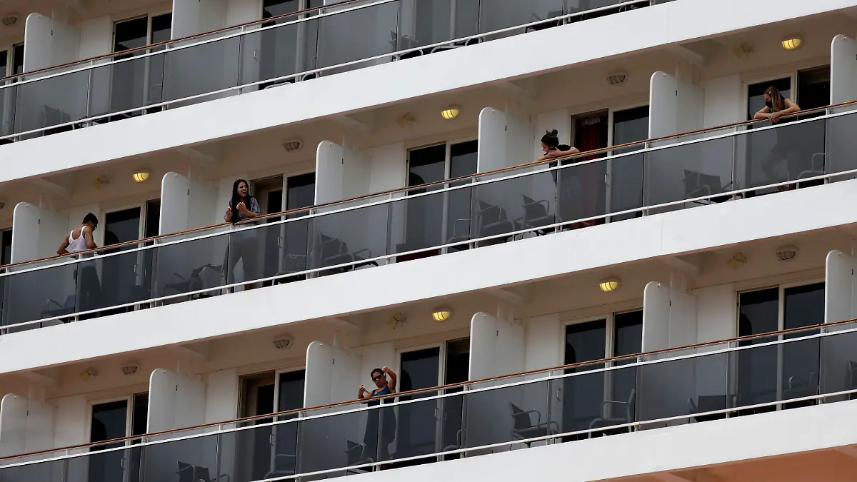 02.01.2022, Brasilien, Rio De Janeiro: Passagiere unterhalten sich auf den Balkonen der Kabinen des Kreuzfahrtschiffs «MSC Preziosa» im Hafengebiet, nachdem die brasilianische Gesundheitsbehörde weitere Fälle des Coronavirus an Bord bestätigt hat. Wie das Gesundheitssekretariat von Rio mitteilte, werden die Einwohner der Stadt und der umliegenden Regionen in ihren Häusern unter Quarantäne gestellt. Diejenigen, die außerhalb des Bundesstaates leben, werden in Hotels isoliert. Foto: Bruna Prado/AP/dpa +++ dpa-Bildfunk +++
