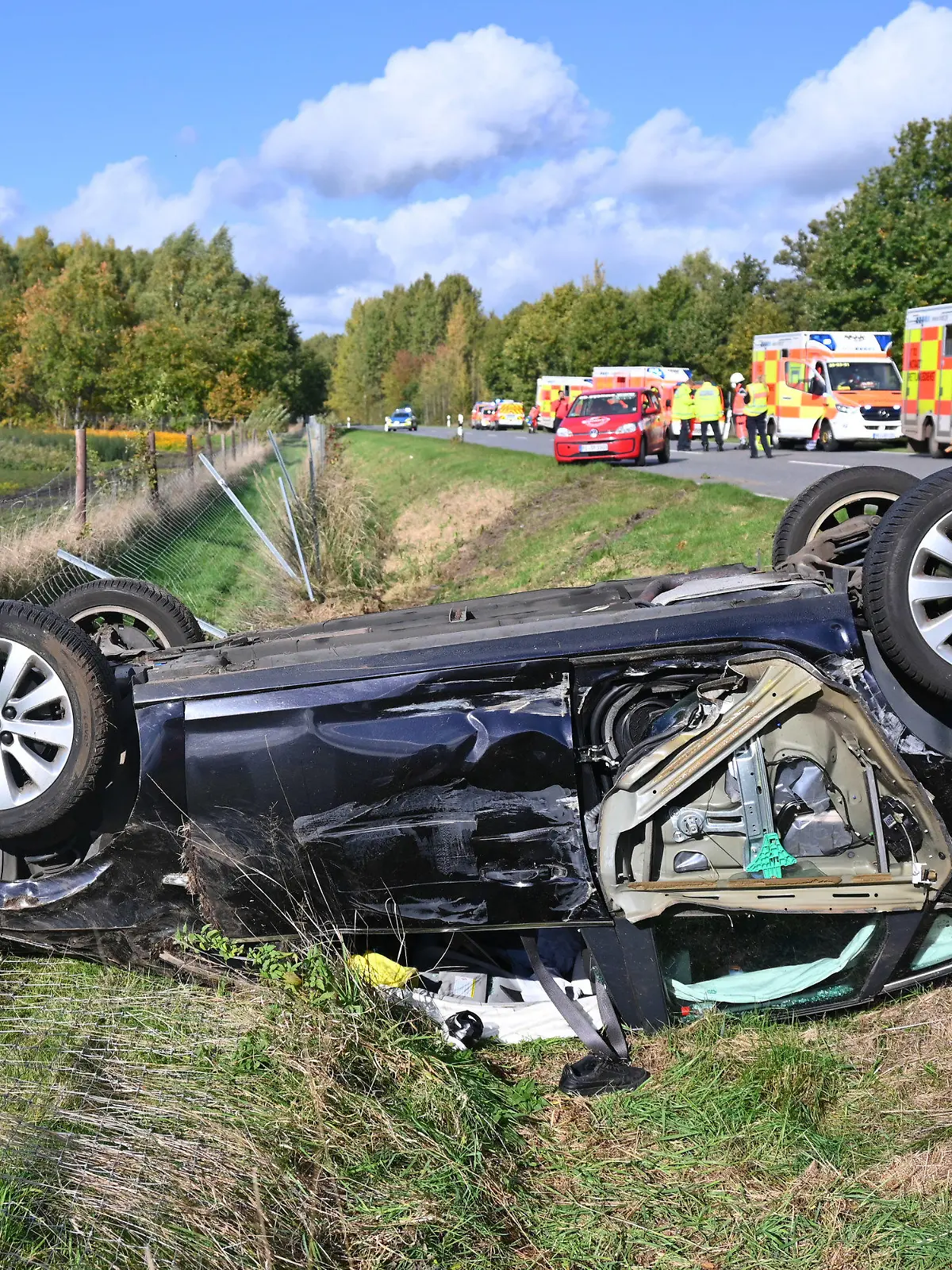 18.10.2022, Schleswig-Holstein, Pinneberg: Das zerstörte Auto liegt auf dem Dach im Straßengraben. Fünf Personen sind bei einem Verkehrsunfall auf einer Landstraße bei Pinneberg verletzt worden. Laut Polizei schwebt eine Achtjährige in Lebensgefahr. Foto: Jonas Walzberg/dpa +++ dpa-Bildfunk +++