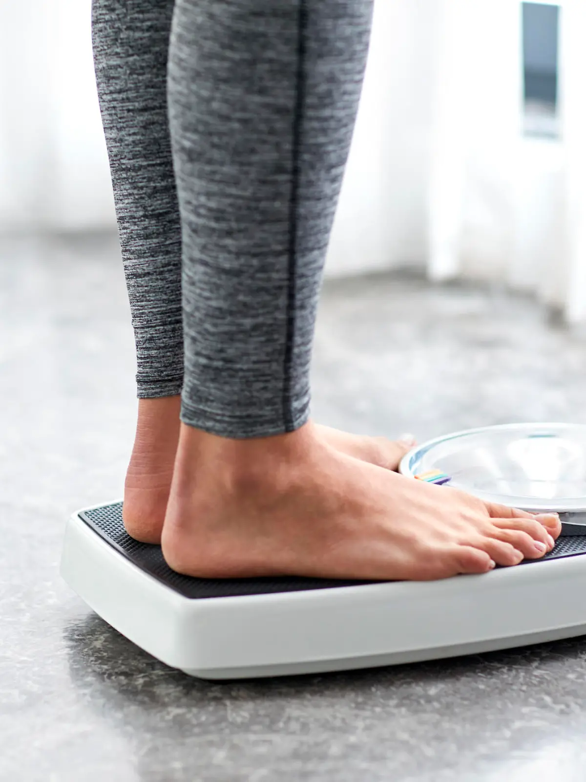 Young healthy girl on home scales