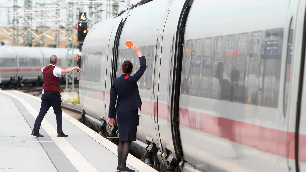 Zugbegleiter der DB Deutsche n Bahn AG signalisieren dem aus dem Fenster schauenden Lokführer mit einer roten Kelle die Abfahrt eines ICE im Hauptbahnhof Leipzig, Sachsen, Deutschland *** DB Deutsche n Bahn AG train attendants signal the departure of an ICE train at Leipzig Central Station, Saxony, Germany, to the driver looking out of the window with a red trowel