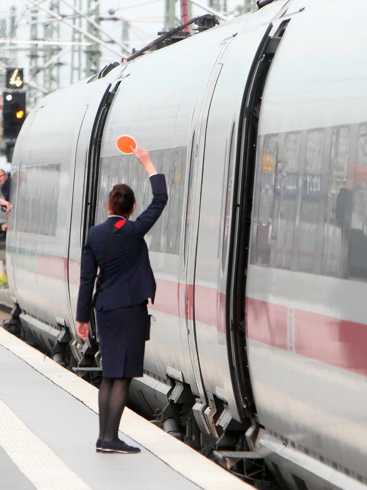  Zugbegleiter der DB Deutsche n Bahn AG signalisieren dem aus dem Fenster schauenden Lokführer mit einer roten Kelle die Abfahrt eines ICE im Hauptbahnhof Leipzig, Sachsen, Deutschland *** DB Deutsche n Bahn AG train attendants signal the departure of an ICE train at Leipzig Central Station, Saxony, Germany, to the driver looking out of the window with a red trowel