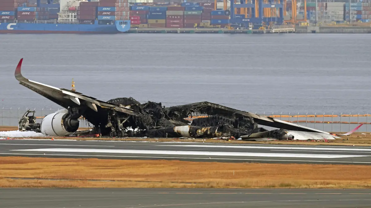 03.01.2024, Japan, Tokio: Das ausgebrannte Flugzeug der Japan Airlines ist auf dem Flughafen Haneda zu sehen. Ein Passagierflugzeug der Japan Airlines (JAL) stieß am Dienstag aus noch ungeklärter Ursache unmittelbar nach der Landung mit einem Flugzeug der japanischen Küstenwache zusammen, das Hilfsgüter zu Überlebenden der Erdbebenkatastrophe auf der Halbinsel Noto bringen sollte. Fünf Menschen an Bord des Küstenwachenflugzeugs kamen dabei ums Leben. Foto: Uncredited/Kyodo News/AP +++ dpa-Bildfunk +++