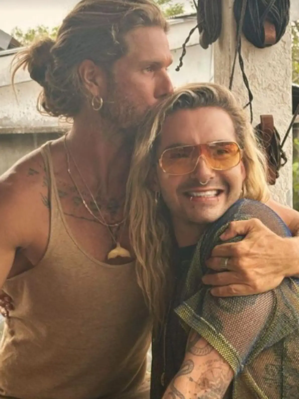 Bill Kaulitz kuschelt sich in den Arm eines blonden Mannes.