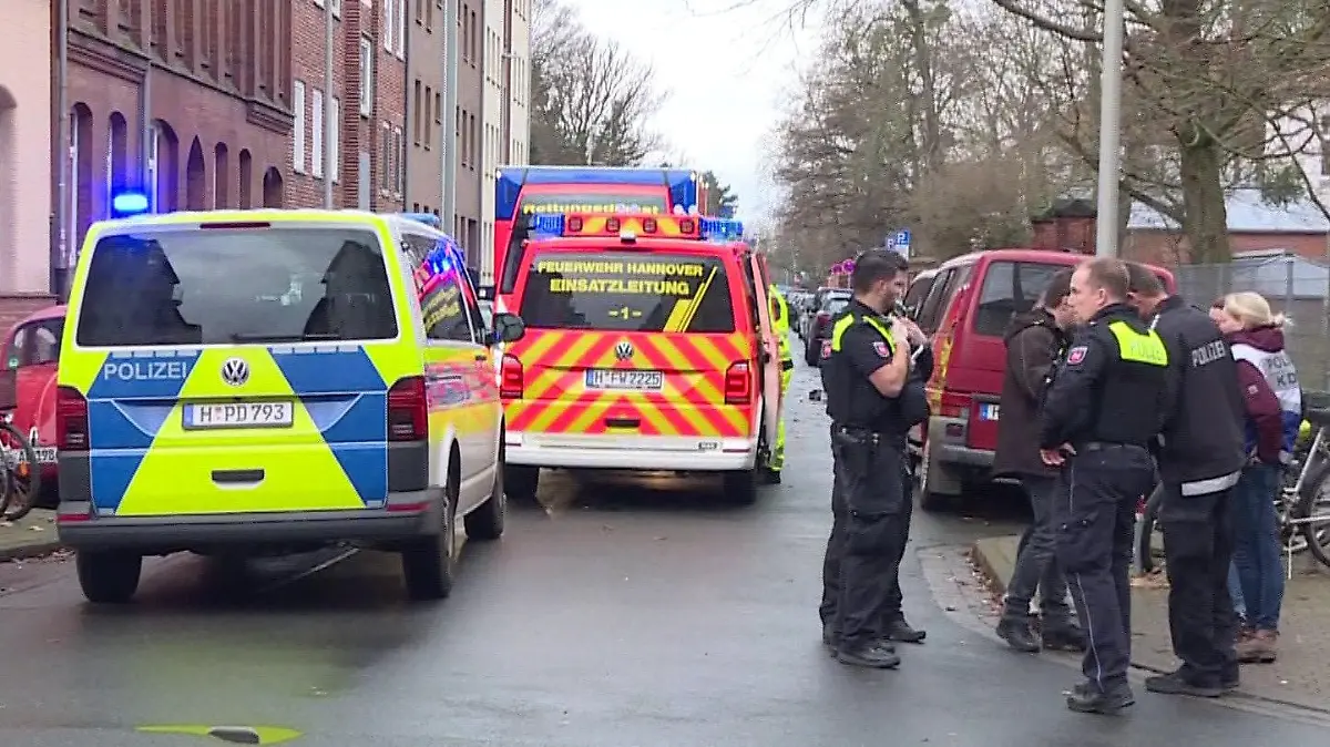 01.01.2024, Niedersachsen, Hannover: Einsatzkräfte von Feuerwehr, Polizei und Rettungsdienst sind bei einem Brand mit ihren Fahrzeugen vor Ort. Bei einem Wohnungsbrand in einem Mehrfamilienhaus in Hannover ist ein Mensch gestorben. Eine weitere Person konnte von den Einsatzkräften schwer verletzt aus der Wohnung im ersten Stock gerettet werden und wurde in ein Krankenhaus gebracht. Foto: Str./TNN/dpa +++ dpa-Bildfunk +++