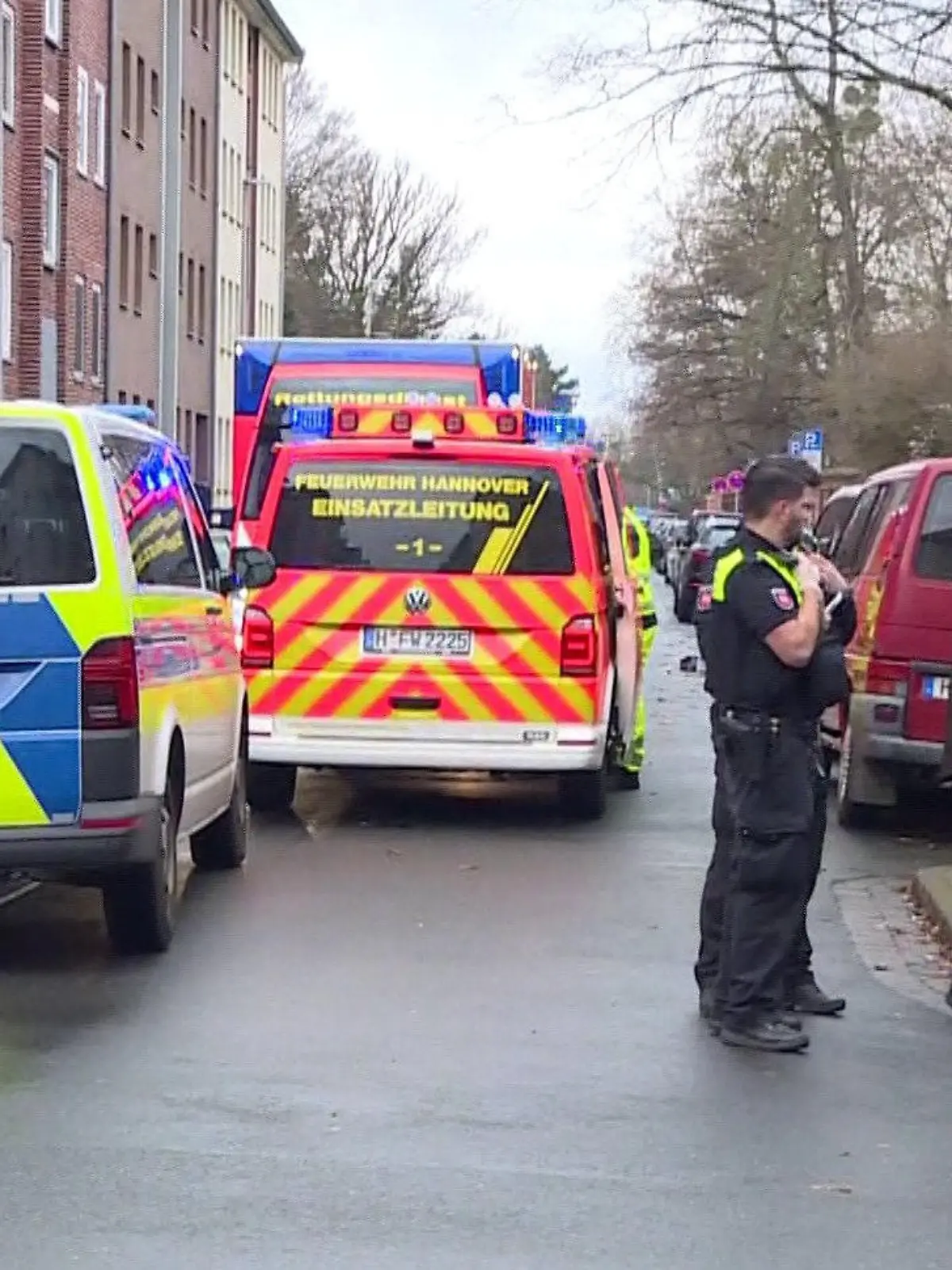 01.01.2024, Niedersachsen, Hannover: Einsatzkräfte von Feuerwehr, Polizei und Rettungsdienst sind bei einem Brand mit ihren Fahrzeugen vor Ort. Bei einem Wohnungsbrand in einem Mehrfamilienhaus in Hannover ist ein Mensch gestorben. Eine weitere Person konnte von den Einsatzkräften schwer verletzt aus der Wohnung im ersten Stock gerettet werden und wurde in ein Krankenhaus gebracht. Foto: Str./TNN/dpa +++ dpa-Bildfunk +++