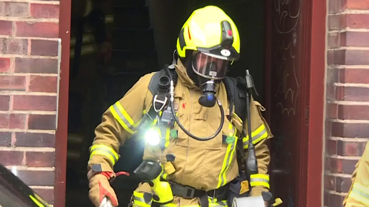 01.01.2024, Niedersachsen, Hannover: Ein Feuerwehrmann kommt bei der Bekämpfung von einem Brand aus einem Wohnhaus. Bei einem Wohnungsbrand in einem Mehrfamilienhaus in Hannover ist ein Mensch gestorben. Eine weitere Person konnte von den Einsatzkräften schwer verletzt aus der Wohnung im ersten Stock gerettet werden und wurde in ein Krankenhaus gebracht. Foto: Str./TNN/dpa +++ dpa-Bildfunk +++