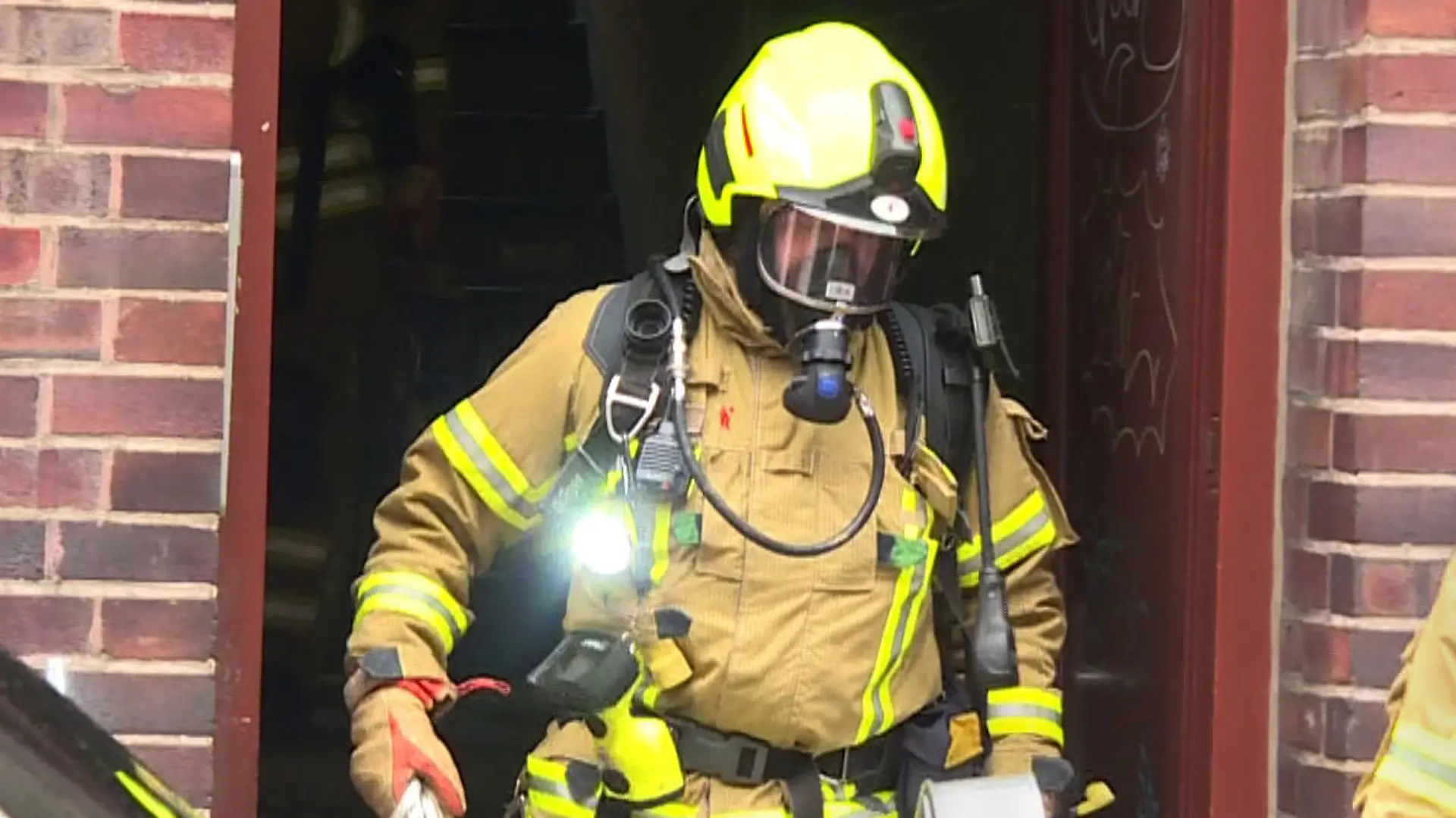 01.01.2024, Niedersachsen, Hannover: Ein Feuerwehrmann kommt bei der Bekämpfung von einem Brand aus einem Wohnhaus. Bei einem Wohnungsbrand in einem Mehrfamilienhaus in Hannover ist ein Mensch gestorben. Eine weitere Person konnte von den Einsatzkräften schwer verletzt aus der Wohnung im ersten Stock gerettet werden und wurde in ein Krankenhaus gebracht. Foto: Str./TNN/dpa +++ dpa-Bildfunk +++