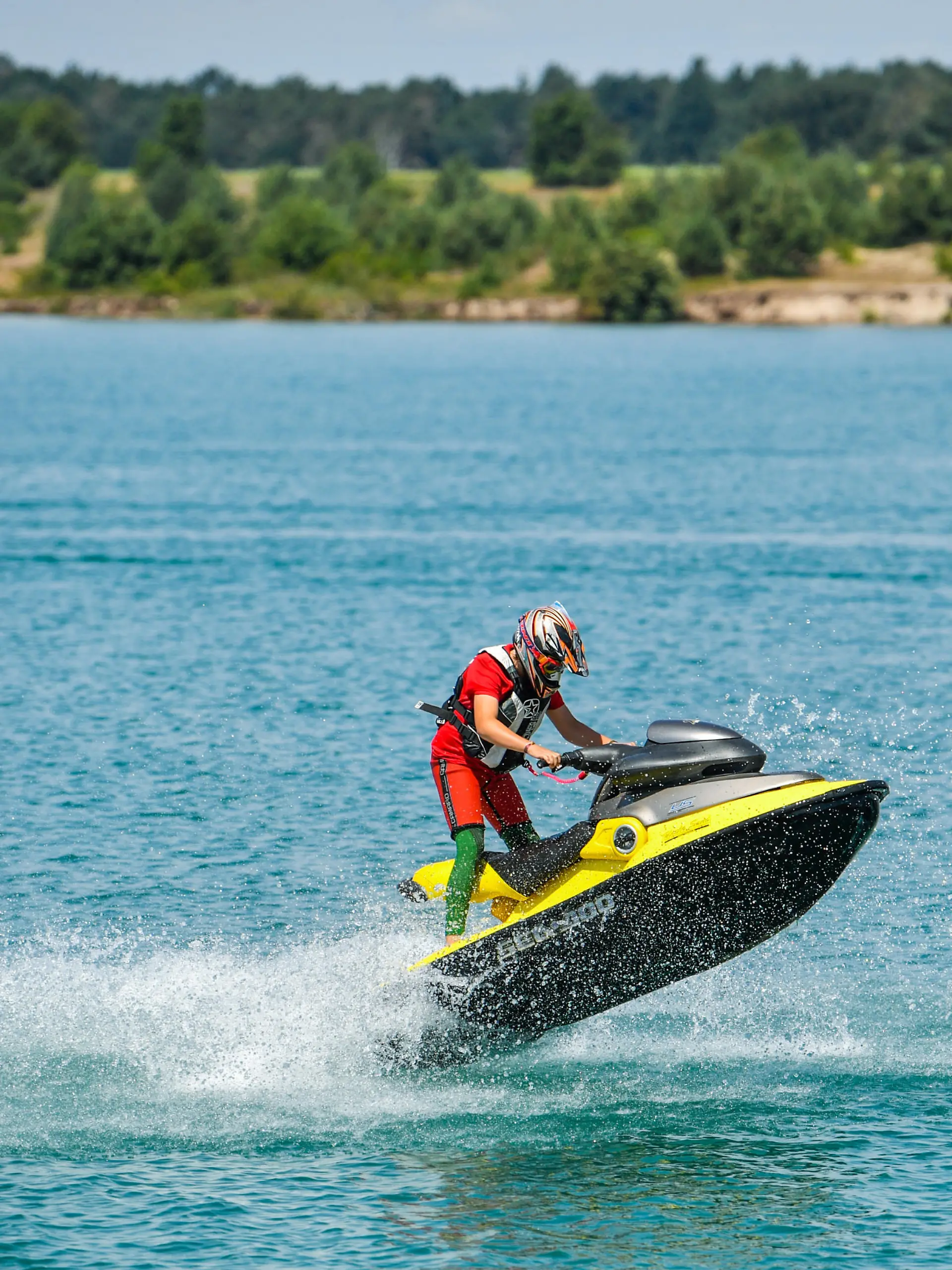 Ein Jet-Ski Fahrer ist am 18.07.2017 auf dem azurblauen Wasser des Partwitzer Sees nahe Klein Partwitz (Sachsen) unterwegs. Der Partwitzer See, der in Brandenburg und Sachsen liegt, wird derzeit bekalkt und das Wasser ist dadurch azurblau gefärbt. Das Lausitzer Seenland ist eine faszinierende Region im Wandel. Hier, wo einst die Förderung der Braunkohle das Landschaftsbild bestimmte, entsteht durch die Flutung früherer Tagebaue derzeit ein neues Wasserparadies mit rund 14.000 Hektar Wasserfläche. Zehn der über 20 Seen werden künftig durch schiffbare Kanäle erschlossen. Schon jetzt ist der Senftenberger See über den Koschener Kanal mit dem Geierswalder See verbunden. Der mit 1.000 Metern Länge erste schiffbare Kanal im Lausitzer Seenland beeindruckt mit seiner einzigartigen Bauweise. Der Kanal unterquert eine Bundesstraße und den Fluss Schwarze Elster. Foto: Patrick Pleul/dpa-Zentralbild/ZB | Verwendung weltweit