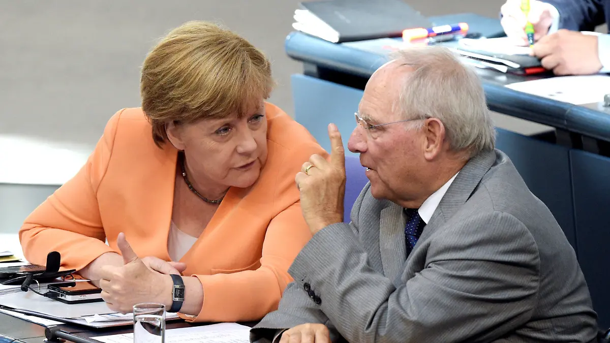 ARCHIV - 01.07.2015, Berlin: Bundeskanzlerin Angela Merkel und der damalige Bundesfinanzminister Wolfgang Schäuble (beide CDU) unterhalten sich am 01.07.2015 im Bundestag in Berlin. Der frühere Bundestagspräsident Wolfgang Schäuble ist tot. Der CDU-Politiker sei im Kreise seiner Familie zu Hause am Dienstagabend gegen 20 Uhr friedlich eingeschlafen.(zu dpa "Früherer Bundestagspräsident Wolfgang Schäuble ist tot") Foto: Rainer Jensen/dpa +++ dpa-Bildfunk +++