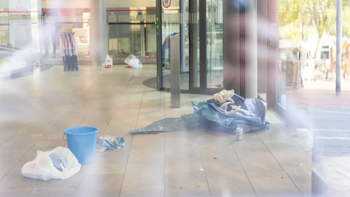 19.10.2022, Schleswig-Holstein, Schleswig: Gegenstände liegen im Vorraum einer Sparkassenfiliale. In einer Sparkassenfiliale in Schleswig sind am Mittwoch zwei tote Menschen gefunden worden. Hintergründe seien noch unbekannt, die Ermittlungen liefen zur Stunde noch, sagte ein Polizeisprecher am Vormittag. Bisher gebe es keinerlei Anhaltspunkte, die für oder gegen ein Tötungsdelikt sprächen. Foto: Benjamin Nolte/dpa +++ dpa-Bildfunk +++
