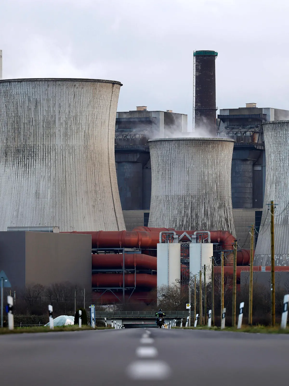 Impression vom RWE-Kraftwerk Bergheim Niederaußem. Das Kohlekraftwerk zieht seine Schwaden in die kalte Winterluft. In der Umgebung glänzen Strommasten, Windräder und Wolkenformationen in der kalten Wintersonne. Stadtwerke geben bekannt: Strompreise steigen für Privathaushalte 2024 um 32 Prozent. Grund ist eine Entscheidung der Bundesregierung, Gelder in Höhe von 5,5 Milliarden zur Stabilisierung der Netzentgelte zu streichen. Themenbild, Symbolbild. Bergheim, 26.12.2023 NRW Deutschland *** Impression of RWEs Bergheim Niederaussem power plant The coal-fired power plant billows out into the cold winter air In the surrounding area, electricity pylons, wind turbines and cloud formations gleam in the cold winter sun Municipal utilities a Copyright: xChristophxHardtx