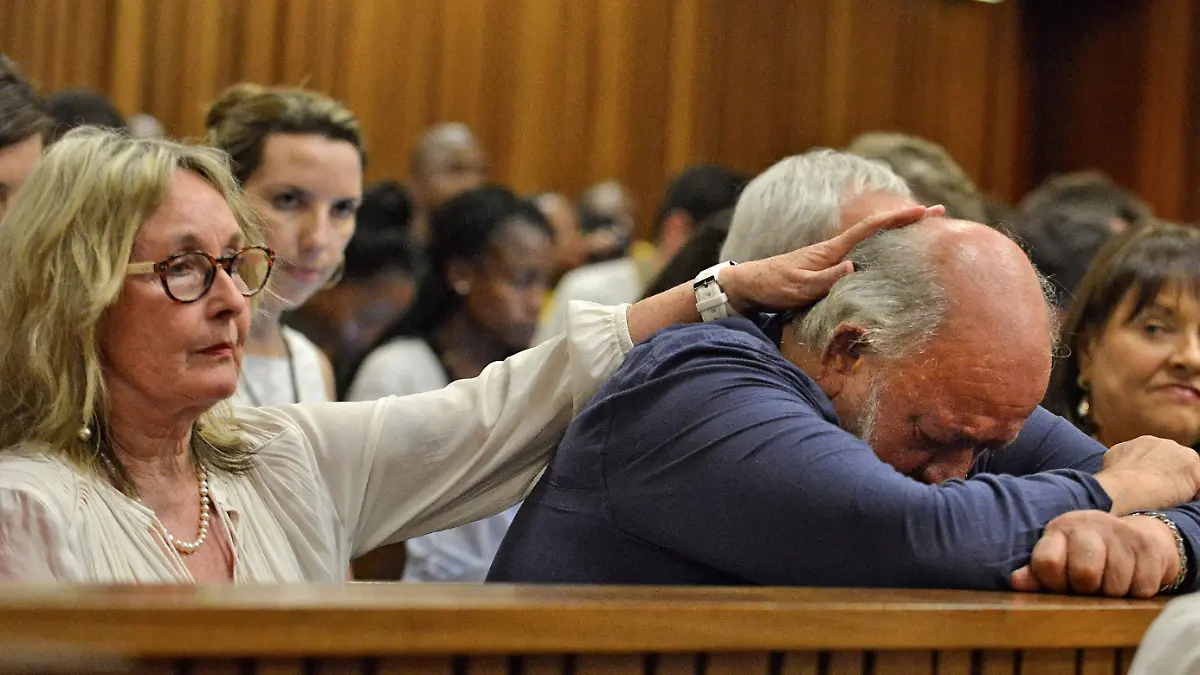FILE PHOTO: Barry Steenkamp, father of Reeva Steenkamp, is consoled by his wife June Steenkamp during the sentencing hearing of Olympic and Paralympic track star Oscar Pistorius at the North Gauteng High Court in Pretoria October 15, 2014. The 27-year-old Pistorius, whose lower legs were amputated as a baby, was convicted of culpable homicide last month for the shooting of 29-year-old law graduate and model Reeva Steenkamp on Valentine's Day 2013. REUTERS/Antoine de Ras/Pool/File Photo