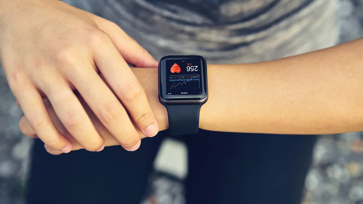 Young woman checking the sports watch measuring heart rate and performance after running.