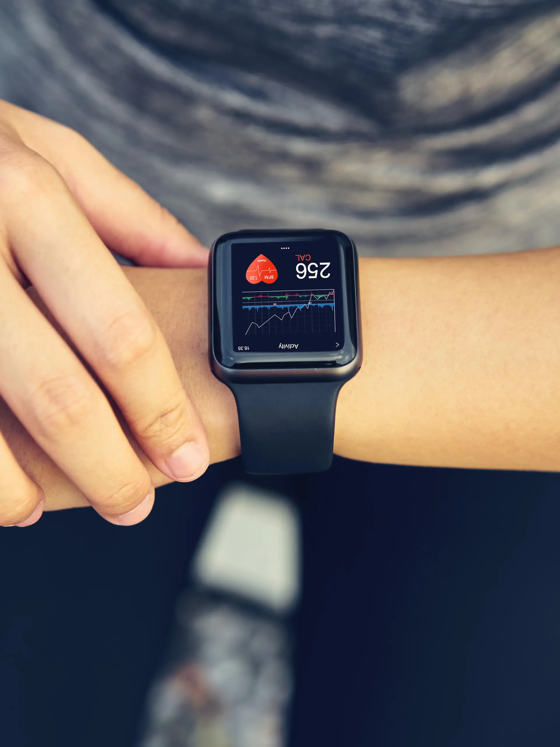 Young woman checking the sports watch measuring heart rate and performance after running.
