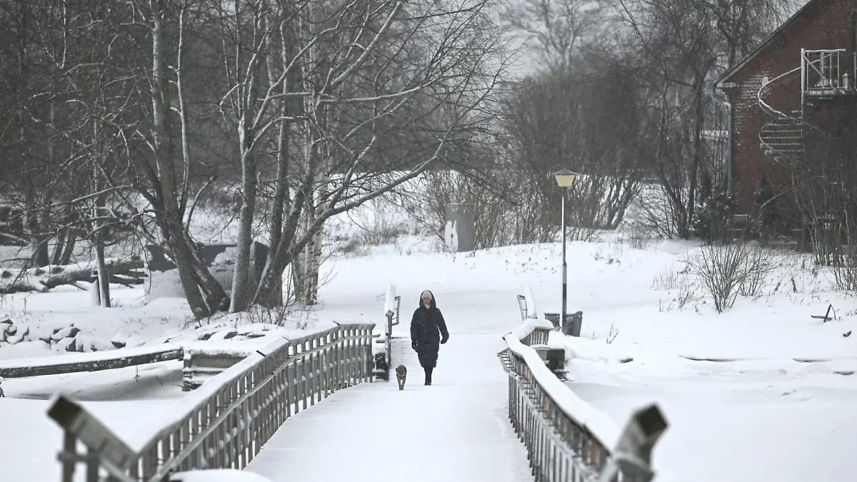 A warmly-dressed woman with the pet dog by the sea in Southern Helsinki in Finland on Thursday, 4th January, 2024. Finland's coldest temperature last night was in Northern Lapland's town of Enontekiö with -42,1c degrees. LEHTIKUVA / HEIKKI SAUKKOMAA - FINLAND OUT. NO THIRD PARTY SALES.  / action press