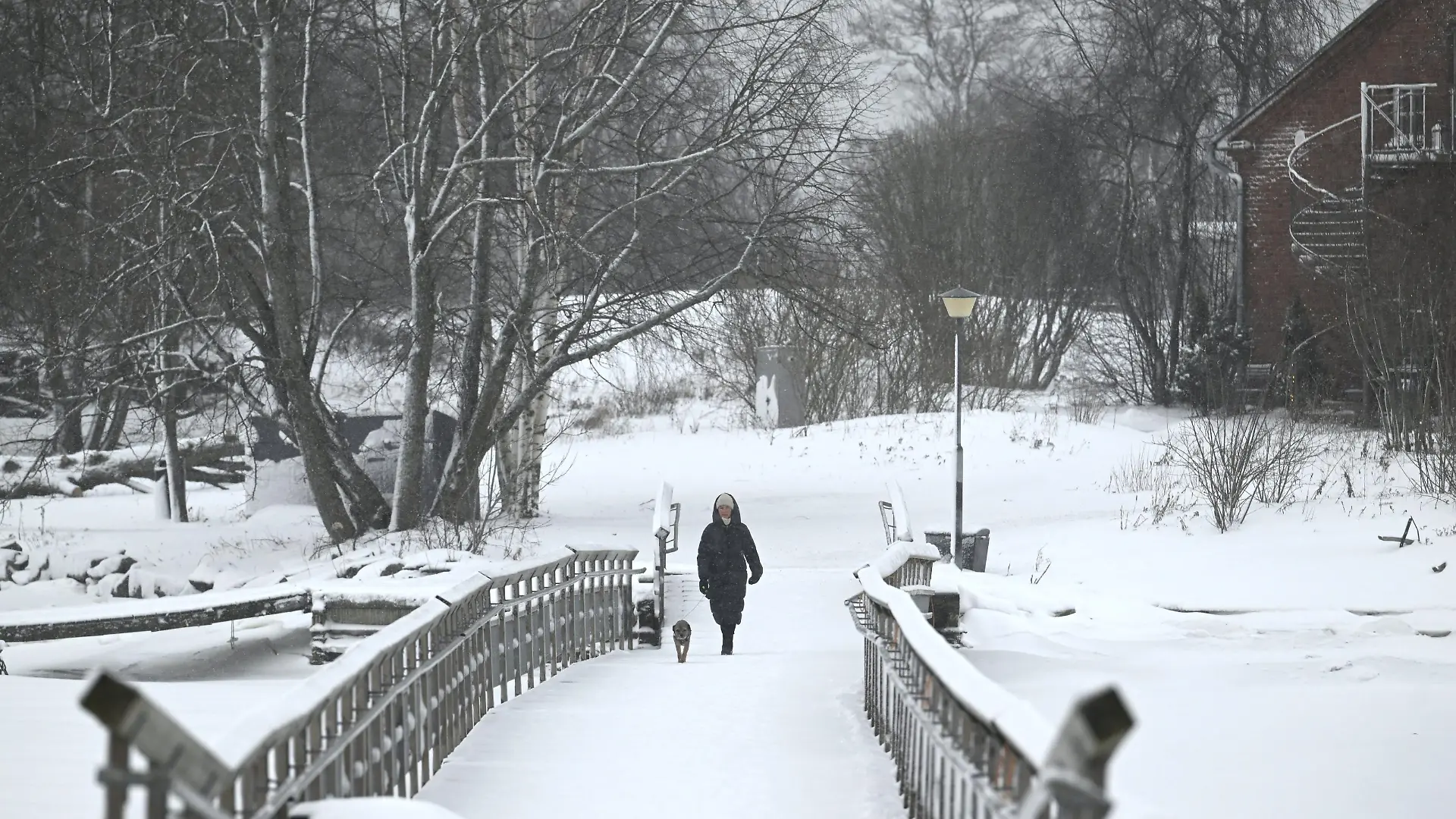 A warmly-dressed woman with the pet dog by the sea in Southern Helsinki in Finland on Thursday, 4th January, 2024. Finland's coldest temperature last night was in Northern Lapland's town of Enontekiö with -42,1c degrees. LEHTIKUVA / HEIKKI SAUKKOMAA - FINLAND OUT. NO THIRD PARTY SALES. / action press