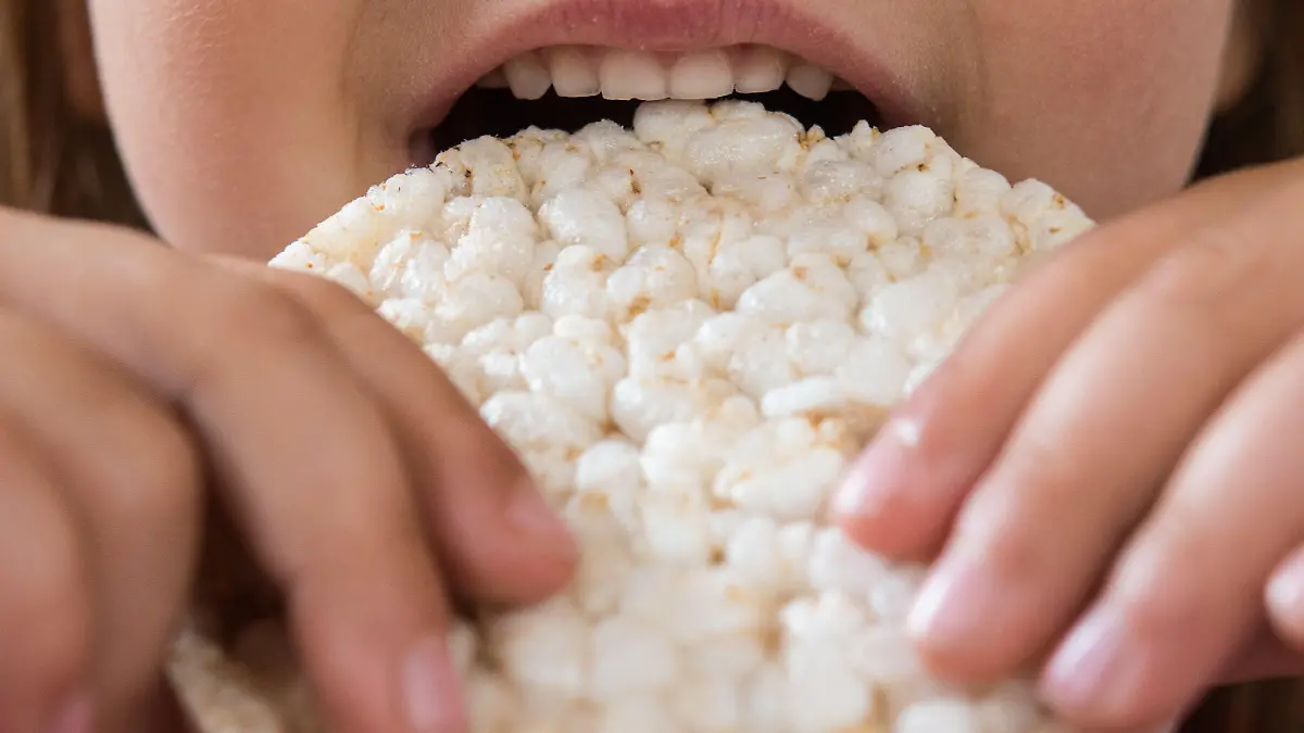 Ein Kind isst eine Reiswaffel.