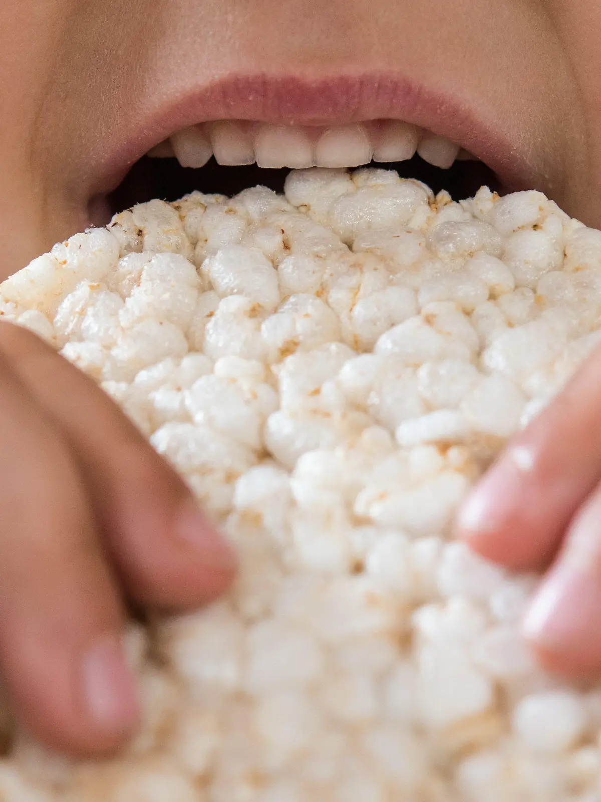 Ein Kind isst eine Reiswaffel.