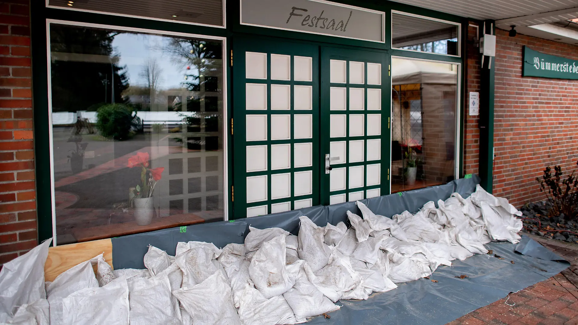 03.01.2024, Niedersachsen, Oldenburg: Zahlreiche Sandsäcke liegen vor dem Eingang zum Festsaal am Bümmersteder Krug, um das Restaurant vor einem drohenden Hochwasser zu schützen. Da nach den Vorhersagen des Deutschen Wetterdienstes (DWD) weiter mit Regen zu rechnen ist, bleibt die Lage in Niedersachsen angespannt. Foto: Christian Charisius/dpa +++ dpa-Bildfunk +++