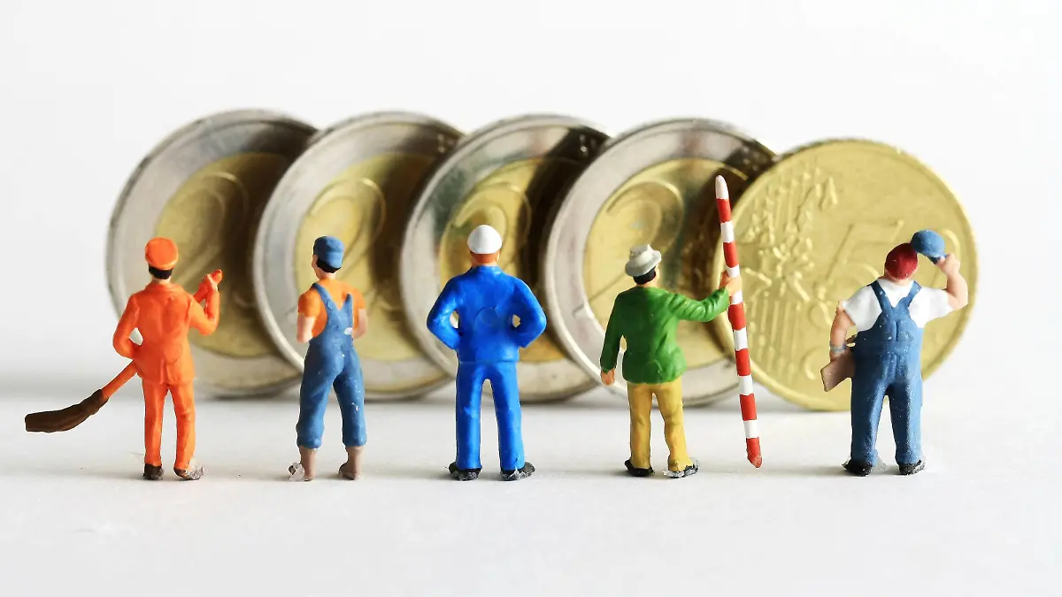  Symbolfoto Mindestlohn:Miniatur Figuren in Arbeitskleidung unterschiedlicher Branchen stehen vor Euro Geldmünzen im Wert von 8,50