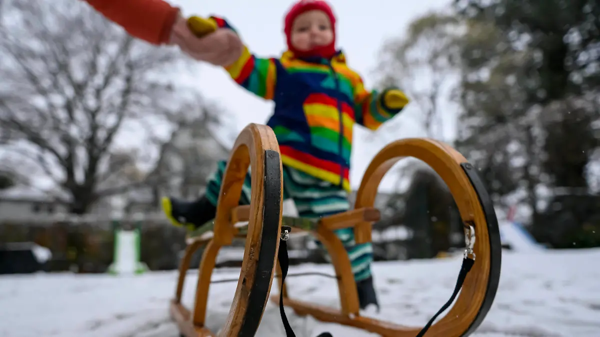 Kind fährt Schlitten im Schnee Ein Kind fährt mit der Mutter im heimischen Garten Schlitten im Schnee, nach Wintereinbruch und erstem Schneefall, Remscheid Lennep Nordrhein-Westfalen Deutschland *** Child sledding in the snow A child sledding with mother in the snow in the home garden, after the onset of winter and first snowfall, Remscheid Lennep North Rhine Westphalia Germany Copyright: xChristopherxNeundorfx