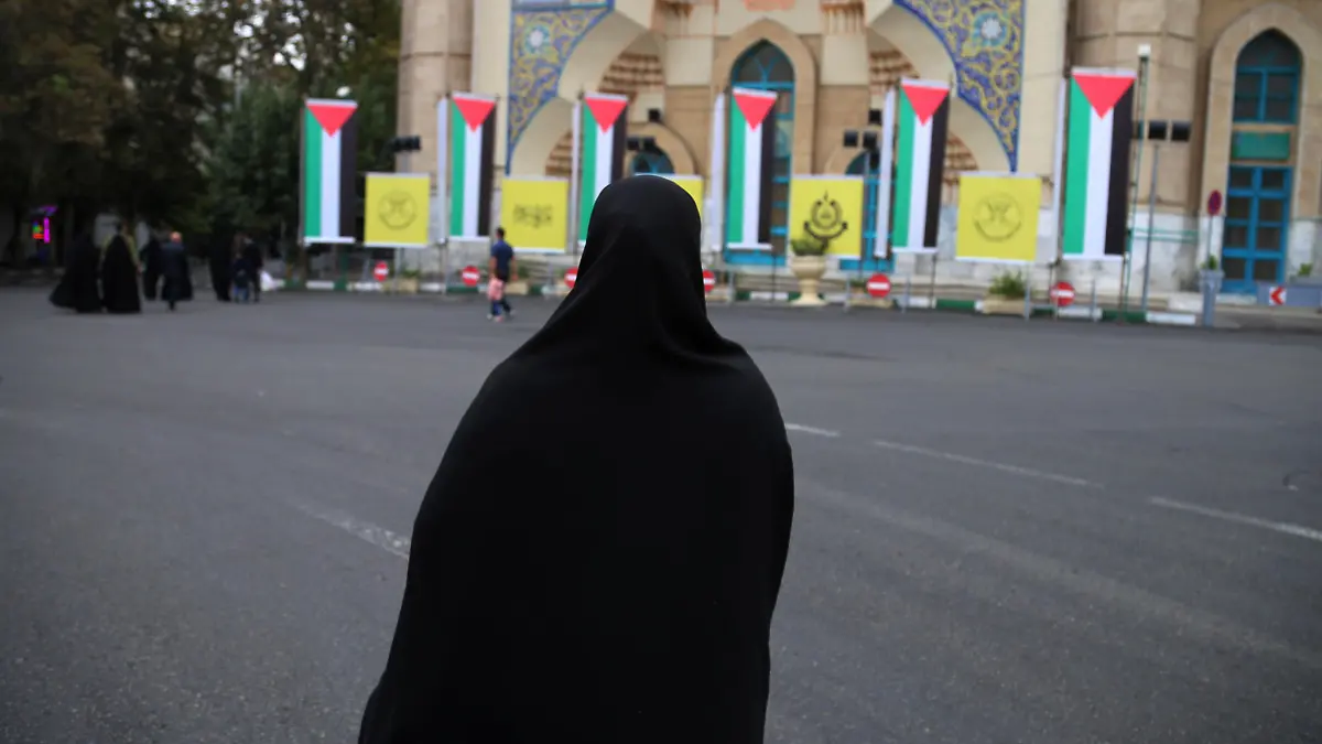 October 13, 2023, Tehran, Iran: An Iranian veiled woman in a black chador walks in front of Palestine flags hanging at Palestine Square in downtown Tehran, symbolizing Iran's support for the Palestinian Al-Aqsa storm missile attack on Israel. The Iranian government openly supported the Hamas attack on Israel and urged the Muslim community to stand by the Palestinians. Hundreds of Israelis and Palestinians have died after the militant group Hamas launched an unprecedented attack on Israel from the Gaza Strip on 07 October 2023. (Credit Image: © Rouzbeh Fouladi/ZUMA Press Wire