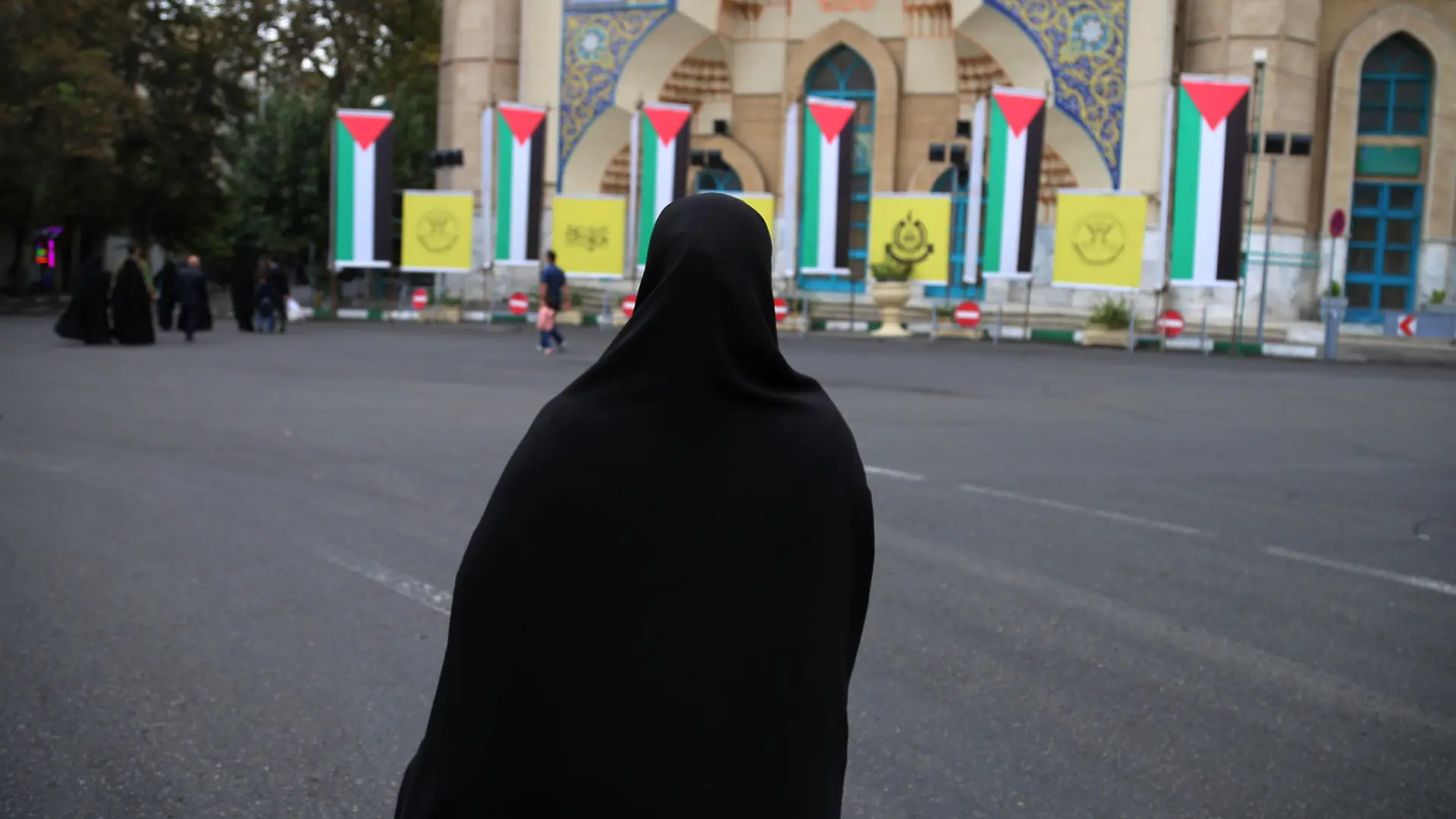 October 13, 2023, Tehran, Iran: An Iranian veiled woman in a black chador walks in front of Palestine flags hanging at Palestine Square in downtown Tehran, symbolizing Iran's support for the Palestinian Al-Aqsa storm missile attack on Israel. The Iranian government openly supported the Hamas attack on Israel and urged the Muslim community to stand by the Palestinians. Hundreds of Israelis and Palestinians have died after the militant group Hamas launched an unprecedented attack on Israel from the Gaza Strip on 07 October 2023. (Credit Image: © Rouzbeh Fouladi/ZUMA Press Wire