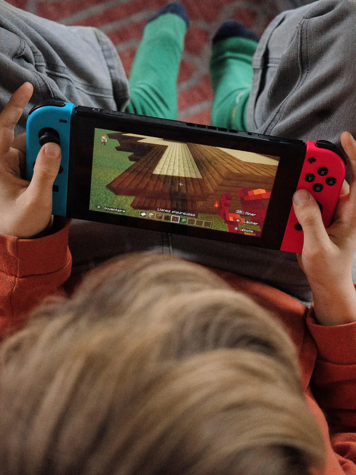 France, Rouans, 2023-01-28. A 9-year-old child plays Minecraft on a game console, the Nintendo Switch. Photograph by Maylis Rolland / Hans Lucas. France, Rouans, 2023-01-28. Un enfant de 9 ans joue a Minecraft sur une console de jeux, la Nintendo Switch. Photographie par Maylis Rolland / Hans Lucas. || Mindestpreis 10 Euro 