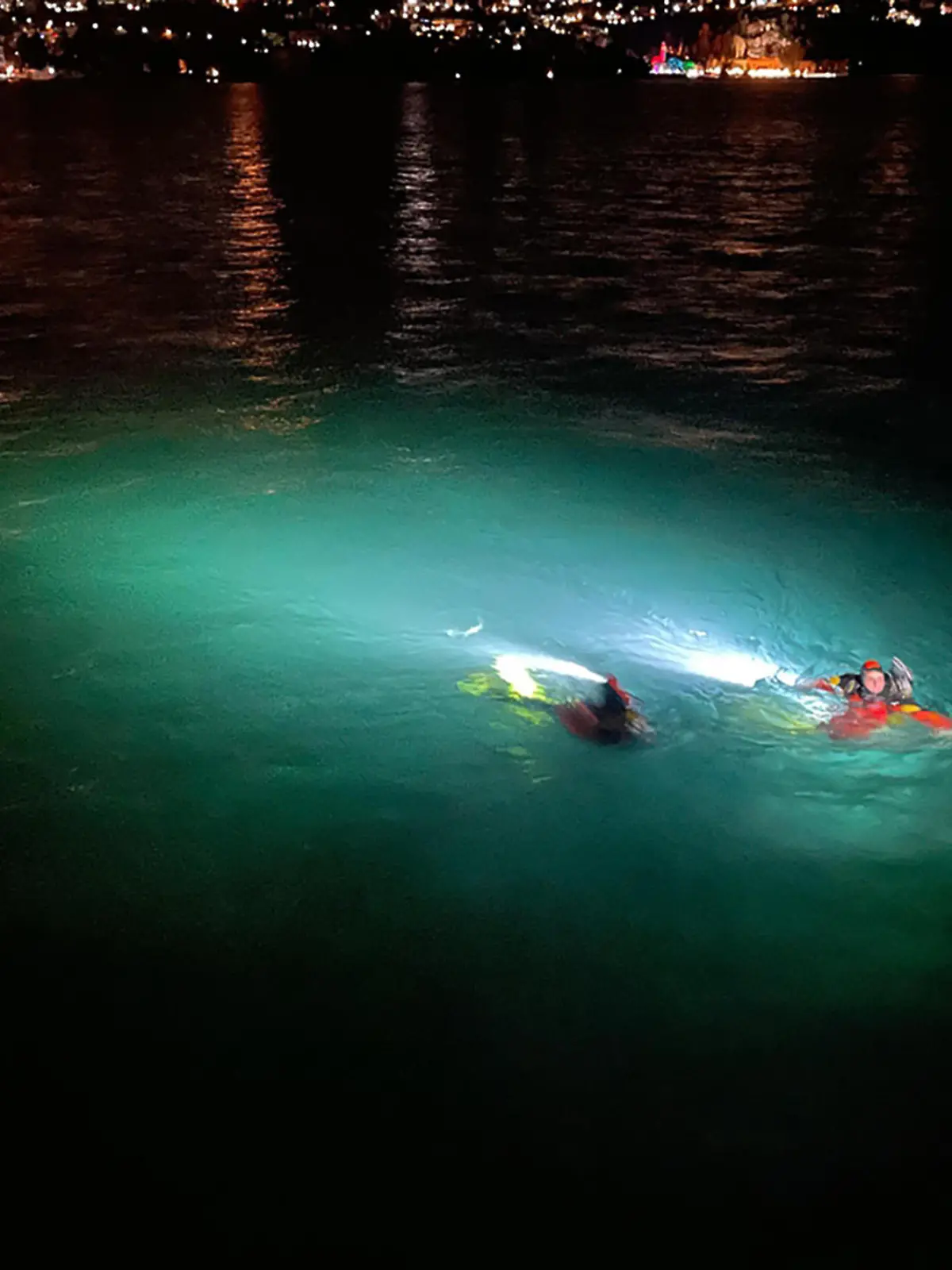 HANDOUT - 07.01.2024, Italien, Como: Rettungskräfte schwimmen im Comer See, in den zwei Menschen mit ihrem Auto gestürzt sind. Die 45 Jahre alte Frau und der 38-jährige Mann konnten am Sonntag nur noch tot aus dem Wasser gezogen werden, wie die Polizei mitteilte. Foto: -/Vigili del Fuoco/dpa - ACHTUNG: Nur zur redaktionellen Verwendung im Zusammenhang mit der aktuellen Berichterstattung und nur mit vollständiger Nennung des vorstehenden Credits +++ dpa-Bildfunk +++