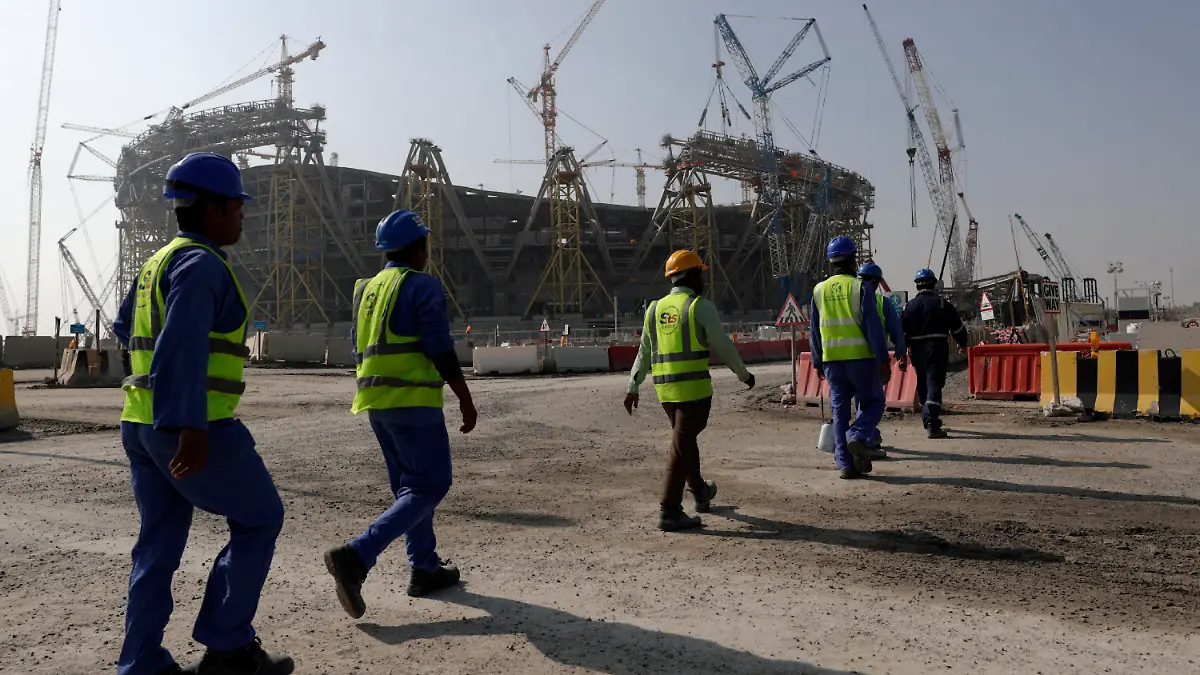 FILE - Workers walk to the Lusail Stadium, one of the 2022 World Cup stadiums, in Lusail, Qatar, Friday, Dec. 20, 2019. Paris has decided not to display the matches of the World Cup in Qatar on giant screens in fan zones amid concerns over rights violations of migrant workers and the environmental impact of the tournament that have led some other French cities to make the same decision. (AP Photo/Hassan Ammar, File)