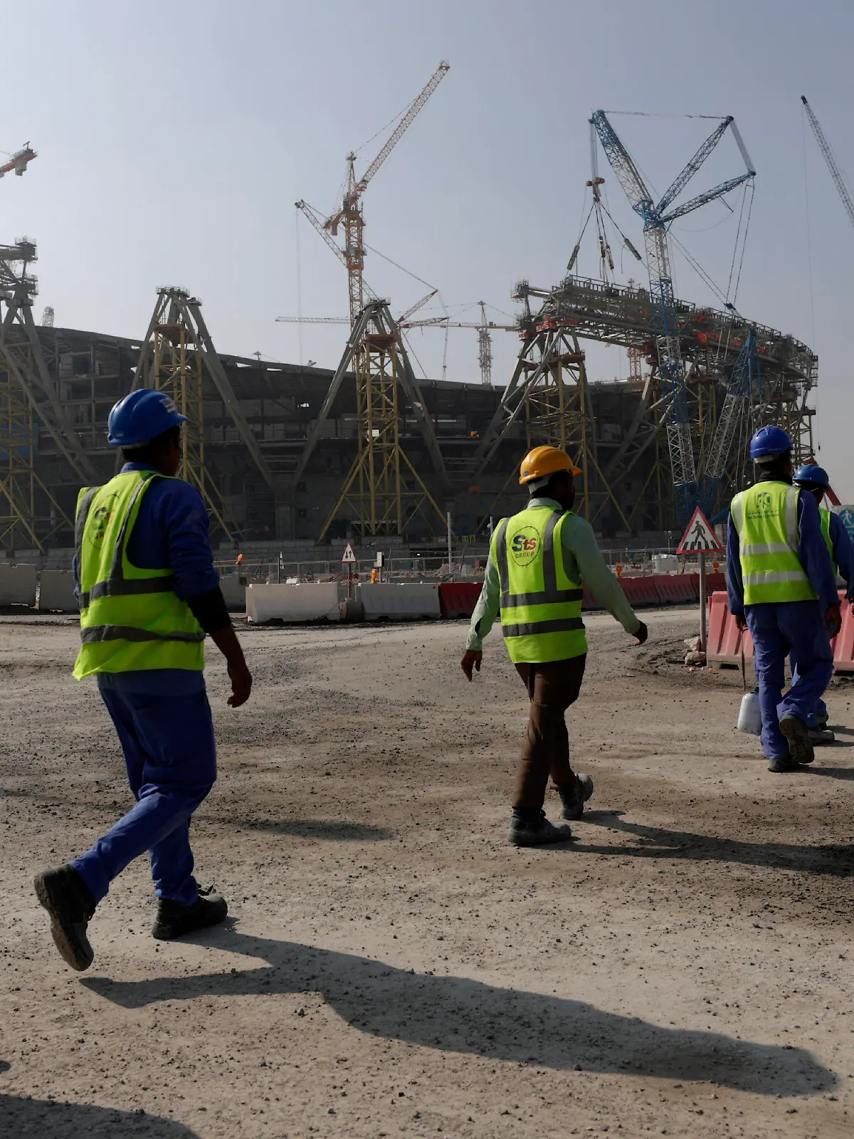 FILE - Workers walk to the Lusail Stadium, one of the 2022 World Cup stadiums, in Lusail, Qatar, Friday, Dec. 20, 2019. Paris has decided not to display the matches of the World Cup in Qatar on giant screens in fan zones amid concerns over rights violations of migrant workers and the environmental impact of the tournament that have led some other French cities to make the same decision. (AP Photo/Hassan Ammar, File)