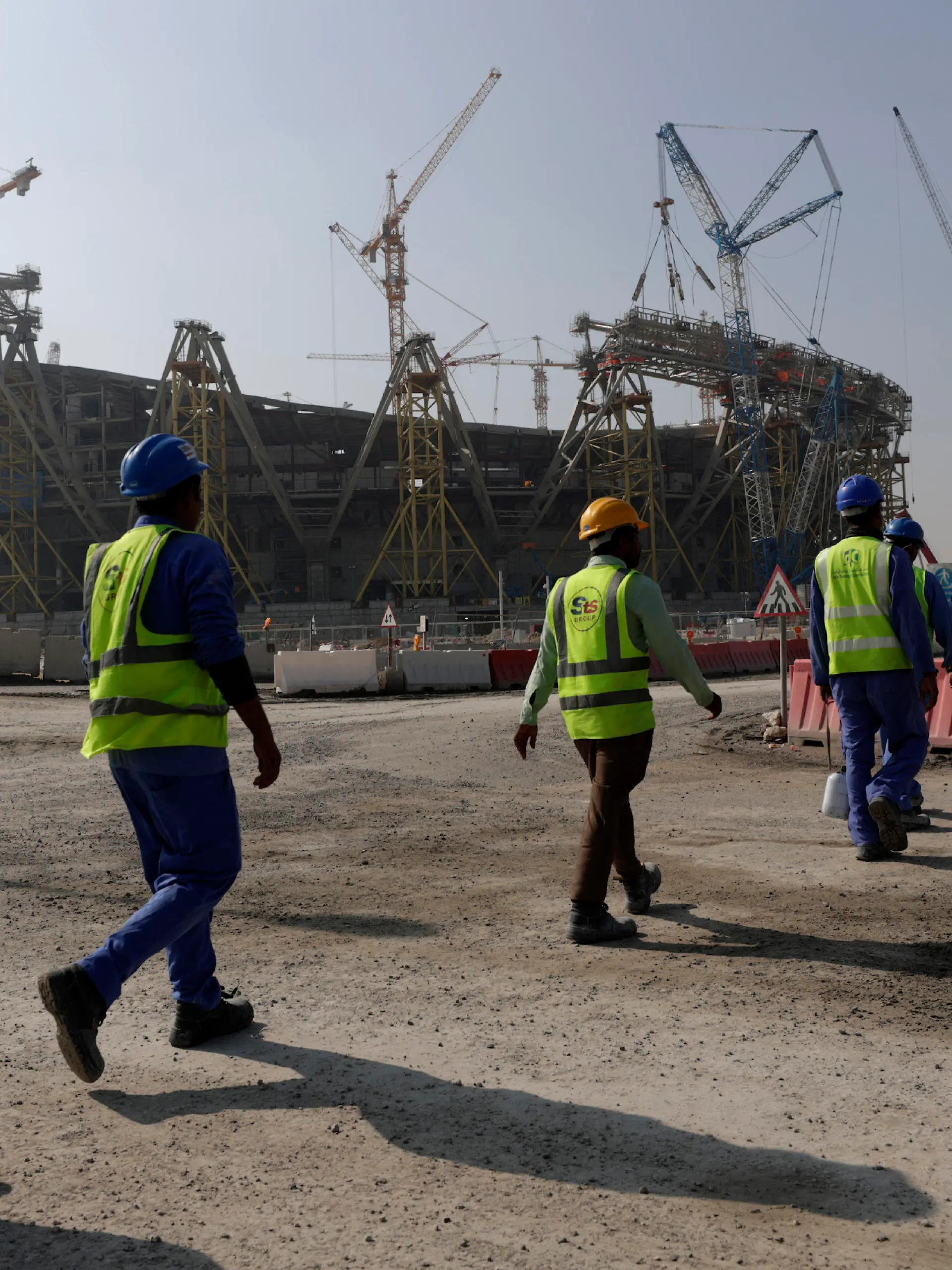 FILE - Workers walk to the Lusail Stadium, one of the 2022 World Cup stadiums, in Lusail, Qatar, Friday, Dec. 20, 2019. Paris has decided not to display the matches of the World Cup in Qatar on giant screens in fan zones amid concerns over rights violations of migrant workers and the environmental impact of the tournament that have led some other French cities to make the same decision. (AP Photo/Hassan Ammar, File)