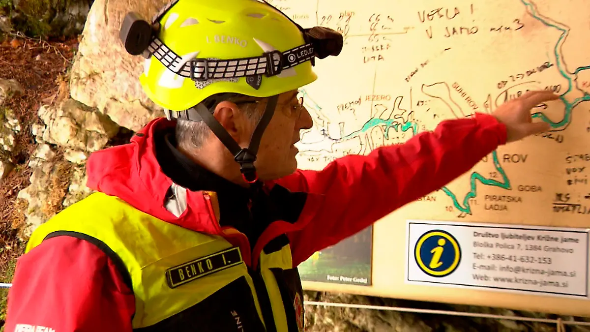 07.01.2024, Slowenien, Grahovo: Auf diesem aus einem Video entnommenen Standbild inspiziert eine Rettungskraft die Karte der Höhle Krizna Jama. Fünf Menschen sind seit mehr als zwei Tagen in der berühmten slowenischen Kreuzhöhle (Krizna Jama) eingeschlossen, weil überraschendes Hochwasser ihren Rückweg versperrt hatte. Foto: -/Pop TV via AP/dpa - ACHTUNG: Verwendung nur bis zum (21.01.2024) +++ dpa-Bildfunk +++