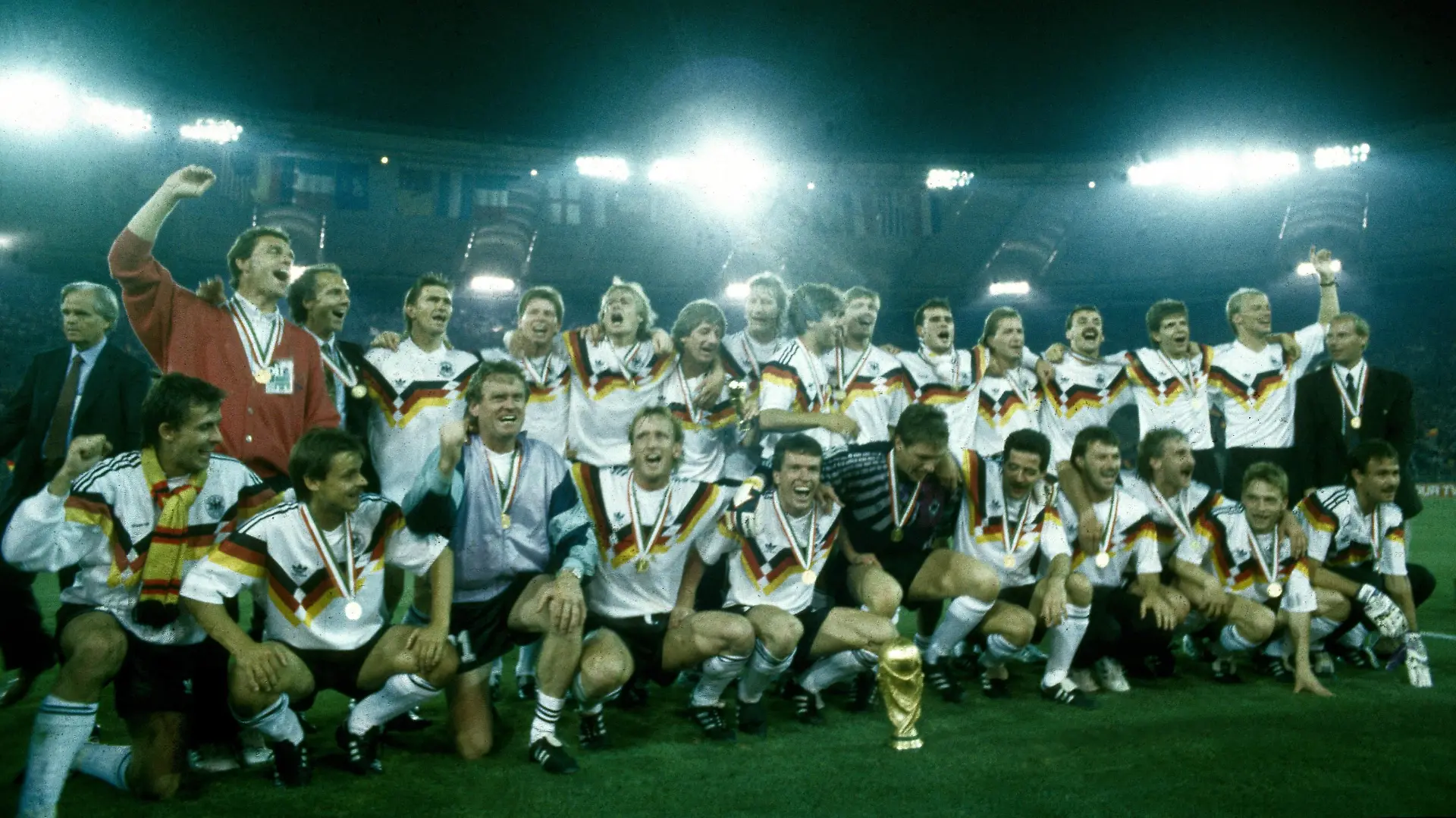 Weltmeisterschaft 1990. Die Deutsche Mannschaft mit WM Pokal nach dem Sieg im Finale am 8.7. in Rom, hi.v.li.: Holger Osieck, Franz Beckenbauer, Klaus Augenthaler, Stefan Reuter, Jürgen Klinsmann, Frank Mill, Guido Buchwald, Karl Heinz Riedle, Paul Steiner, Thomas Berthold, Andreas Köpke, Jürgen Kohler, Andreas Möller, Hansi Pflügler, Berti Vogts, vorn: Pierre Littbarski, Olaf Thon, Sepp Maier, Andreas Brehme, Lothar Matthäus, Bodo Illgner, Uwe Bein, Günter Hermann, Rudi Völler, Thomas Häßler, Raimond Aumann HM