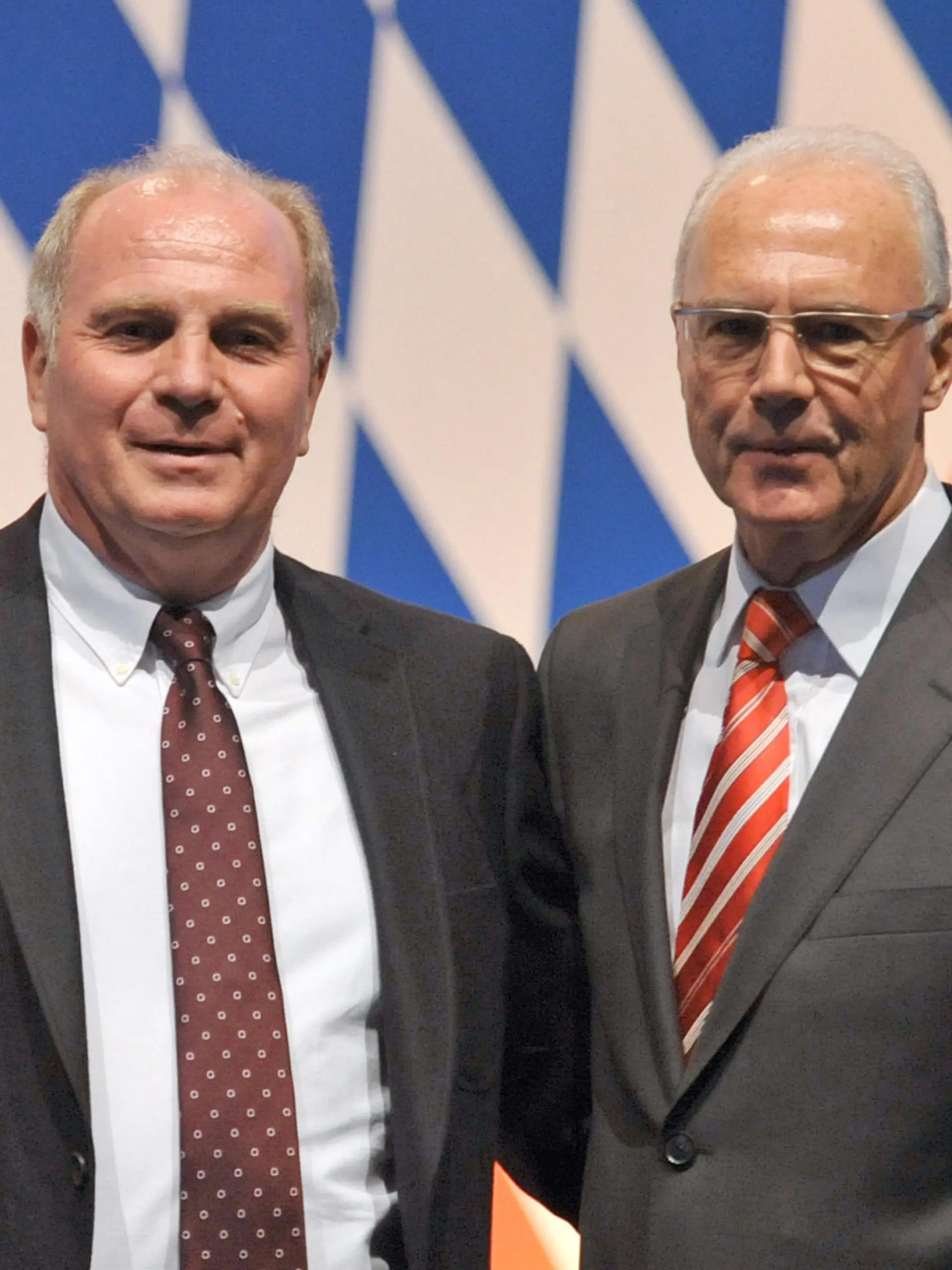 Manager Uli Hoeneß (l) und Präsident Franz Beckenbauer vom Fußball-Bundesligisten FC Bayern München stehen am Freitag (27.11.2009) auf der Jahreshauptversammlung in München (Oberbayern) vor dem Vereinslogo. Beckenbauer soll neuer Ehrenpräsidenten, Hoeneß sein Nachfolger als Präsident des Vereins werden. Der FC Bayern ist mit etwa 150.000 Mitgliedern der drittgrößte und mit einem Jahresumsatz von etwa 300 Millionen Euro einer der wirtschaftsstärksten Sportvereine der Welt. Foto: Andreas Gebert dpa/lby +++(c) dpa - Bildfunk+++