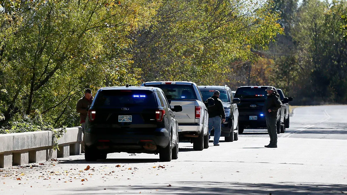 Officials investigate a bridge near the Deep Fork River where bodies were found in Okmulgee, Okla, on Monday, Oct. 17, 2022. (Stephen Pingry/Tulsa World via AP)