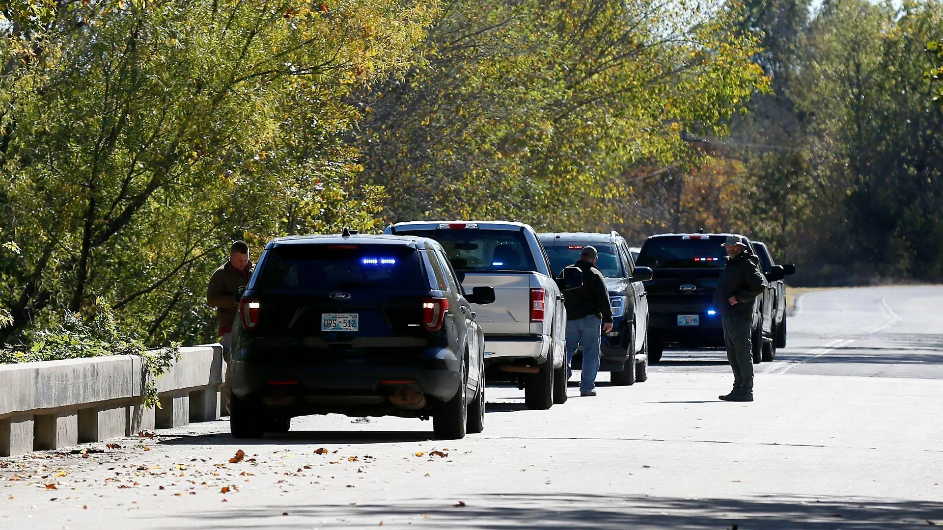 Officials investigate a bridge near the Deep Fork River where bodies were found in Okmulgee, Okla, on Monday, Oct. 17, 2022. (Stephen Pingry/Tulsa World via AP)