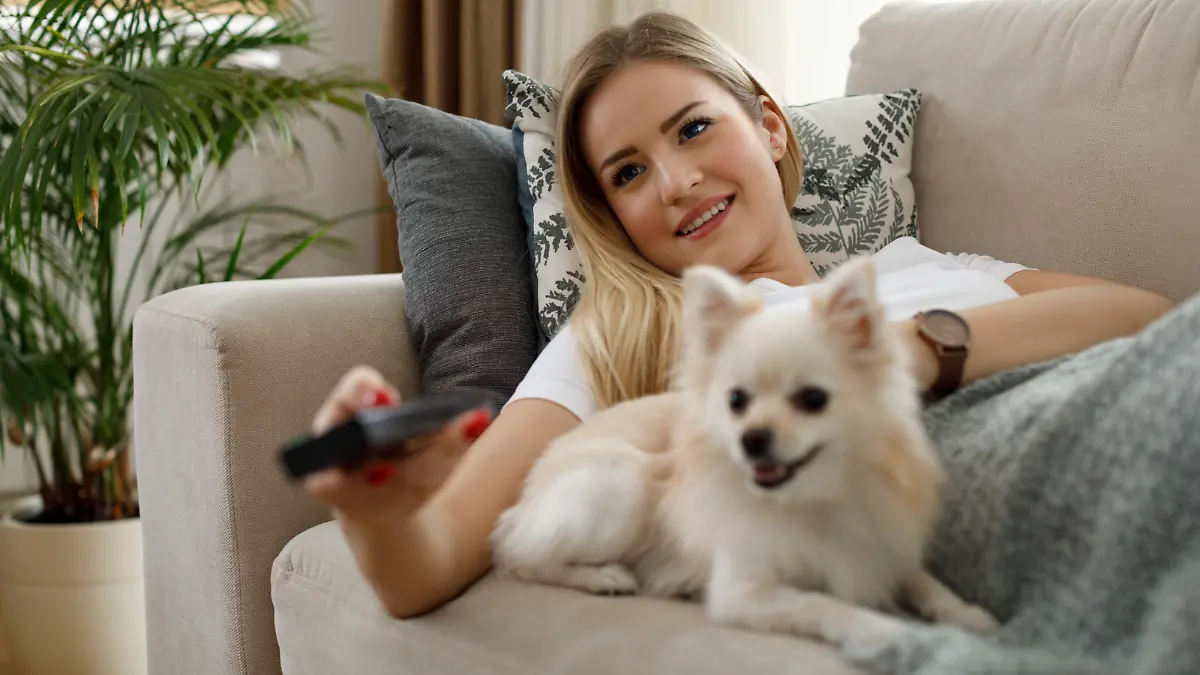 Young woman watching TV at home